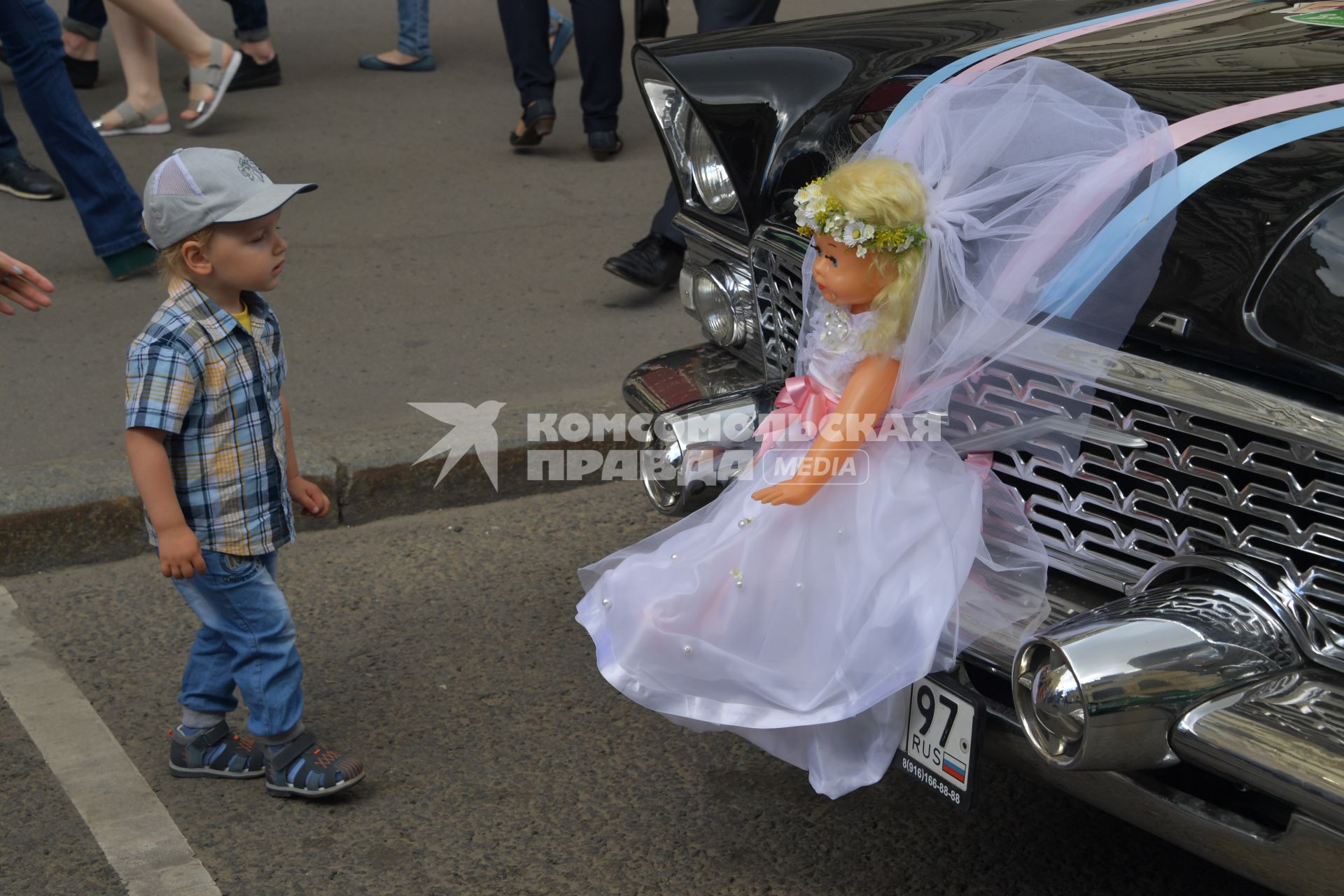 Москва. Мальчик рядом с автомобилем  `Чайка ` на капоте  которой привязана кукла в свадебном платье.