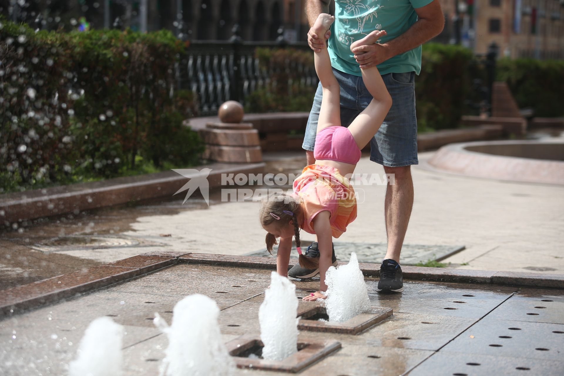 Белоруссия. Минск. Мужчина с девочкой играет у фонтана.