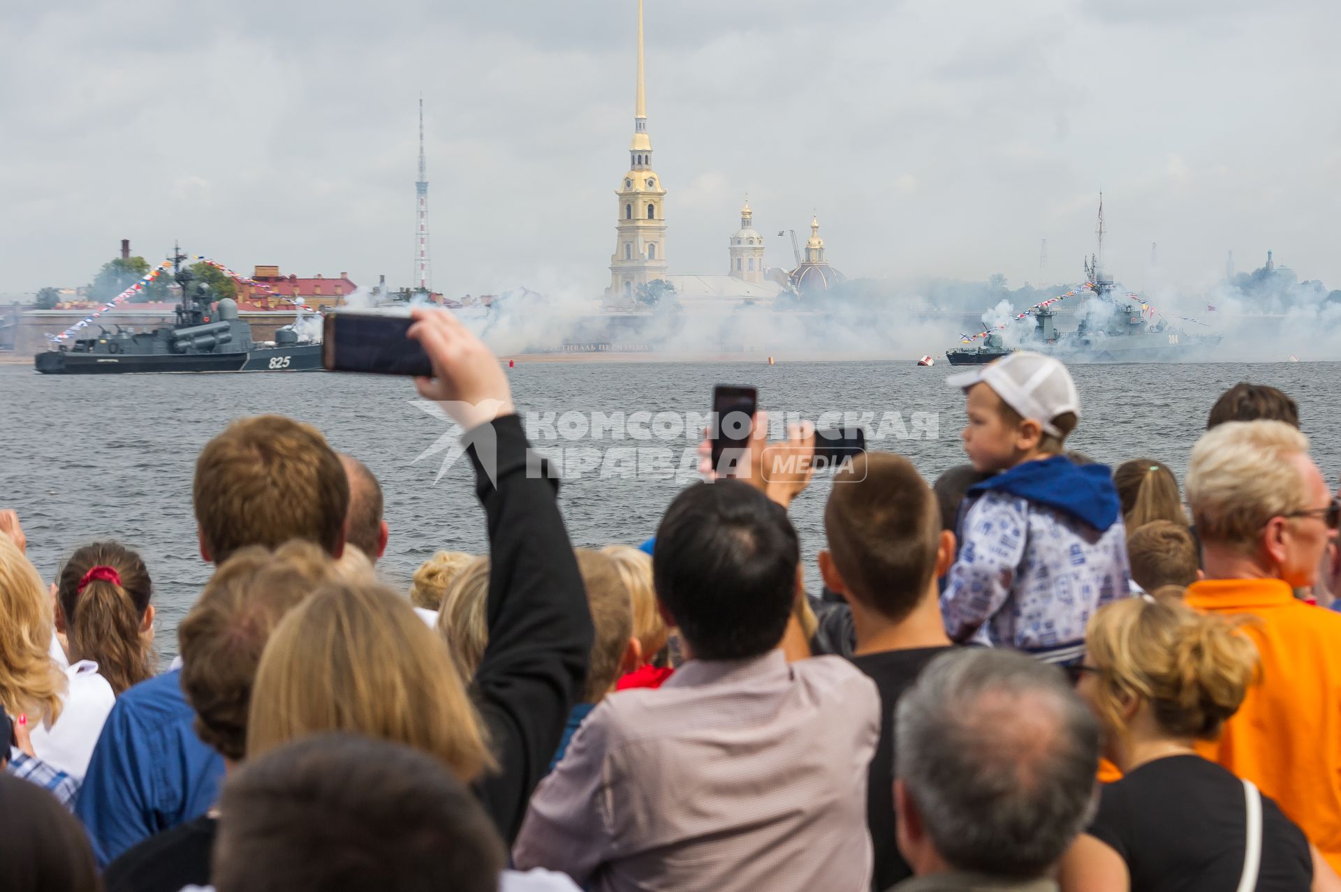 Санкт-Петербург.  Зрители на набережной  фотографируют артиллерийский салют у стен Петропавловской крепости  во время  главного военно-морского  парада  в честь празднования Дня Военно-Морского Флота России.