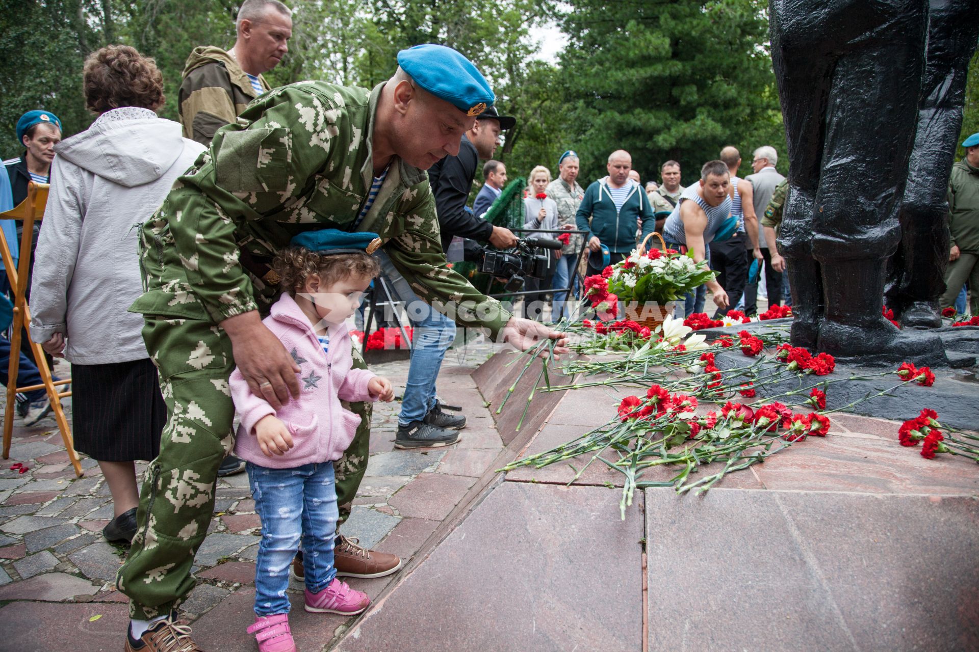 Пермь.  Десантник с ребенком возлагает цветы к памятнику  `Разорванное братство` во время празднования Дня Воздушно-десантных войск России.