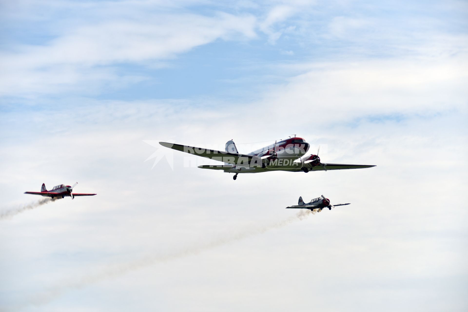 Новосибирская область. Самолеты Douglas DC-3 (в центре) и Як-52 в небе во время авиашоу `Взлетай, мой край родной!` на аэродроме Мочище.