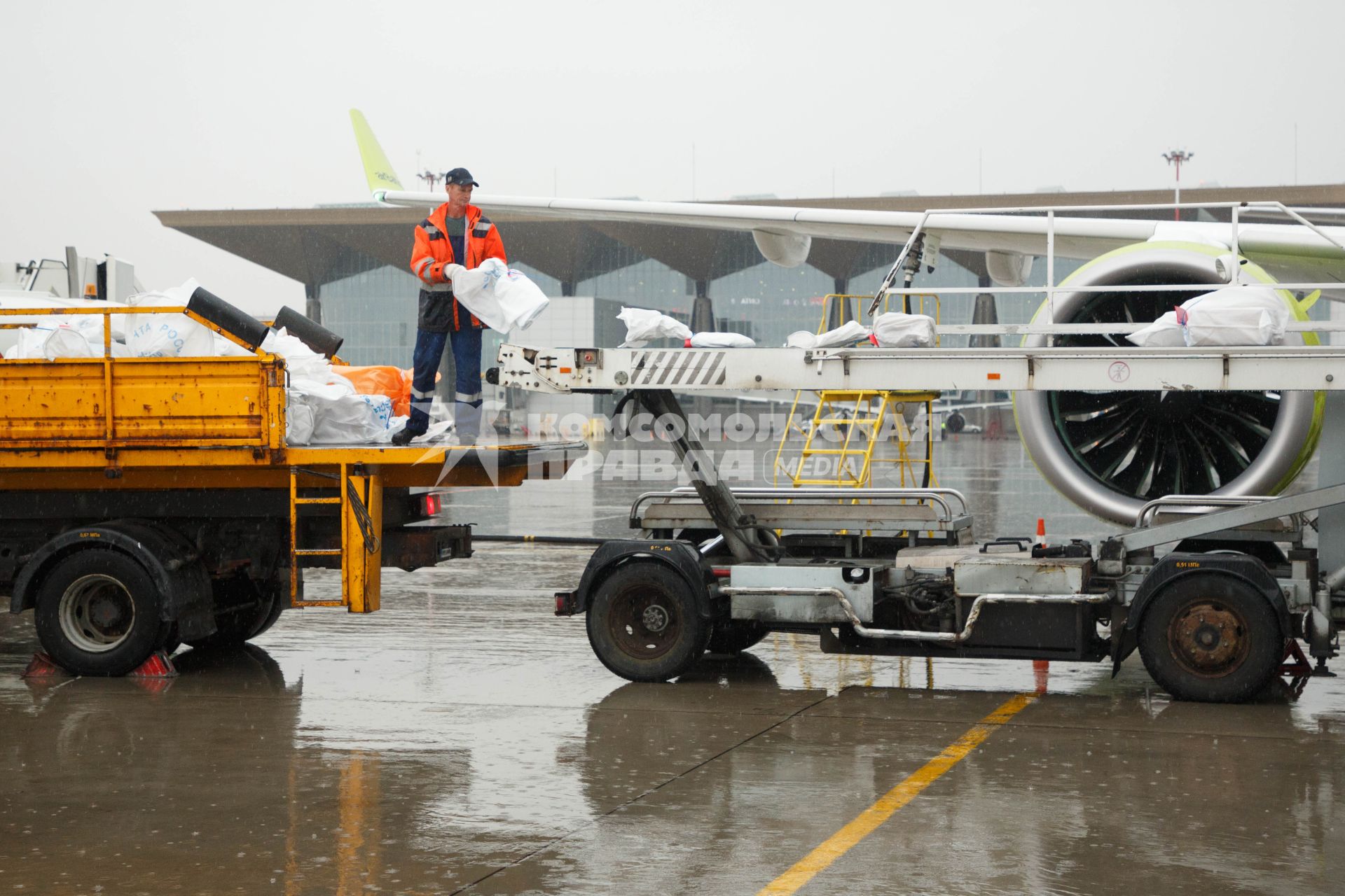 Санкт-Петербург. Загрузка посылок `Почты России` в самолет  Bombardier CS300 авиакомпании airBaltic в аэропорту `Пулково`.