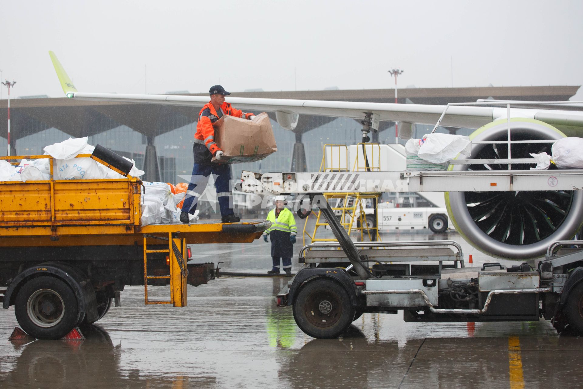 Санкт-Петербург. Загрузка посылок `Почты России` в самолет  Bombardier CS300 авиакомпании airBaltic в аэропорту `Пулково`.