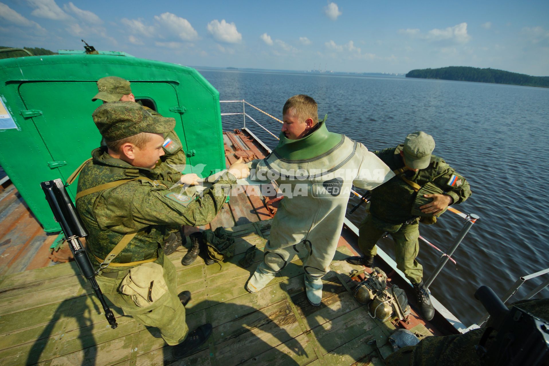 Свердловская область. Военнослужащие помогоют экипироваться водолазу во время тактико-специальных учений соединений железнодорожных войск ЦВО (центральный военный округ) по наведению понтонного моста