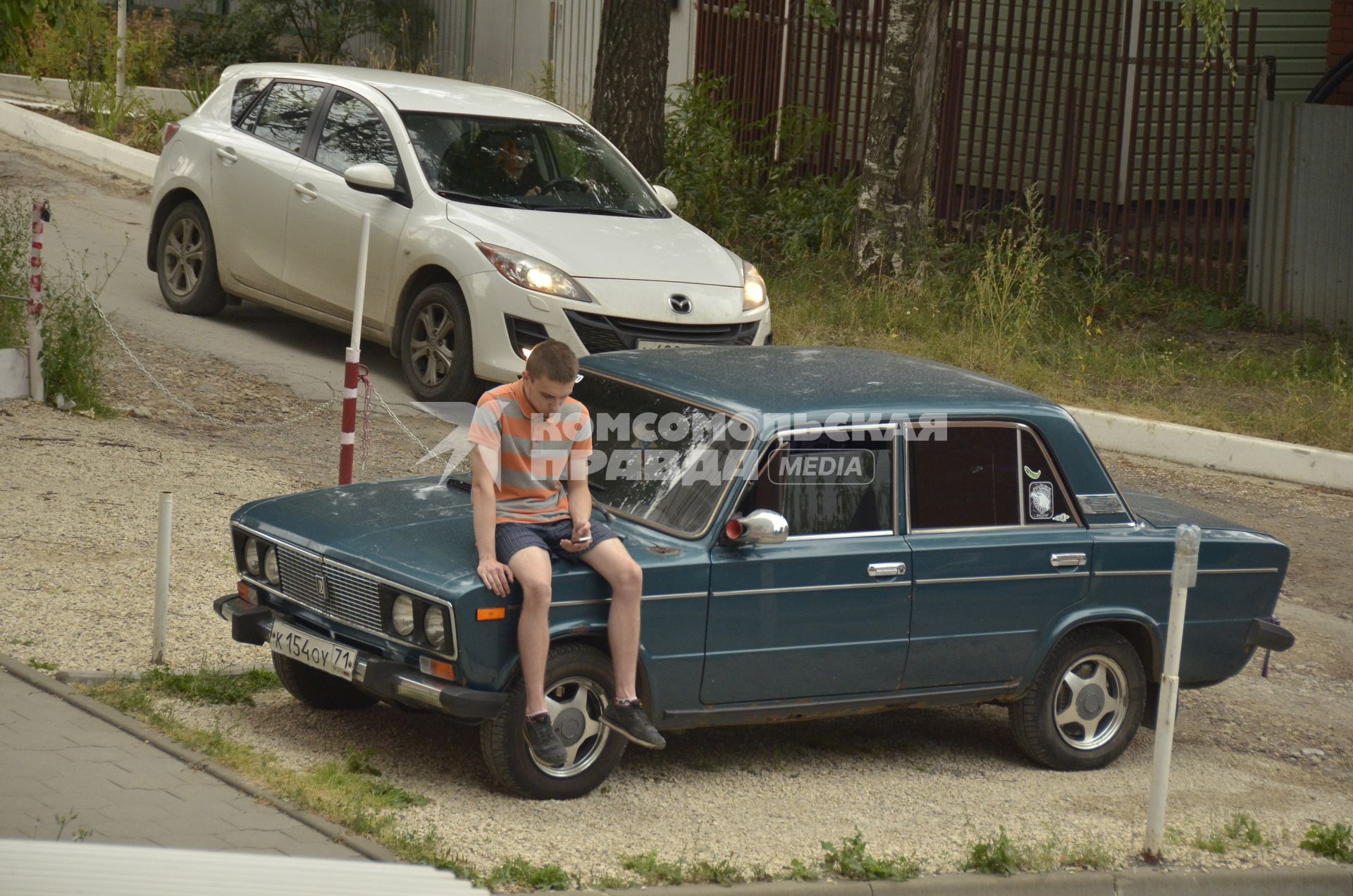 Тула. Молодой человек сидит на капоте автомобиля  ВАЗ-2106.