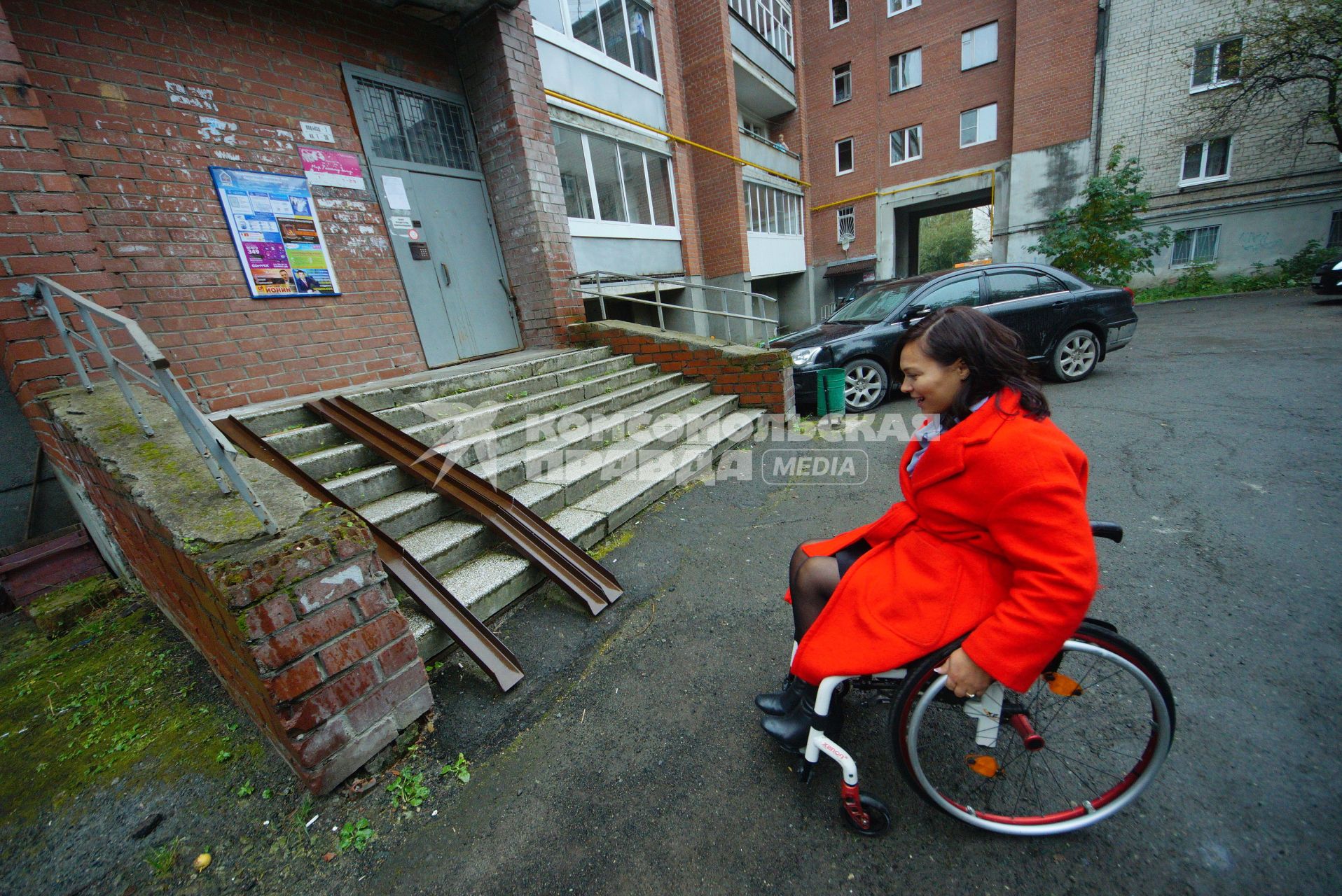 Екатеринбург. Женщина-инвалид-колясочник у жилого дома с пандусом, во время тестирования доступности городской среды для людей с ограниченными возможностями
