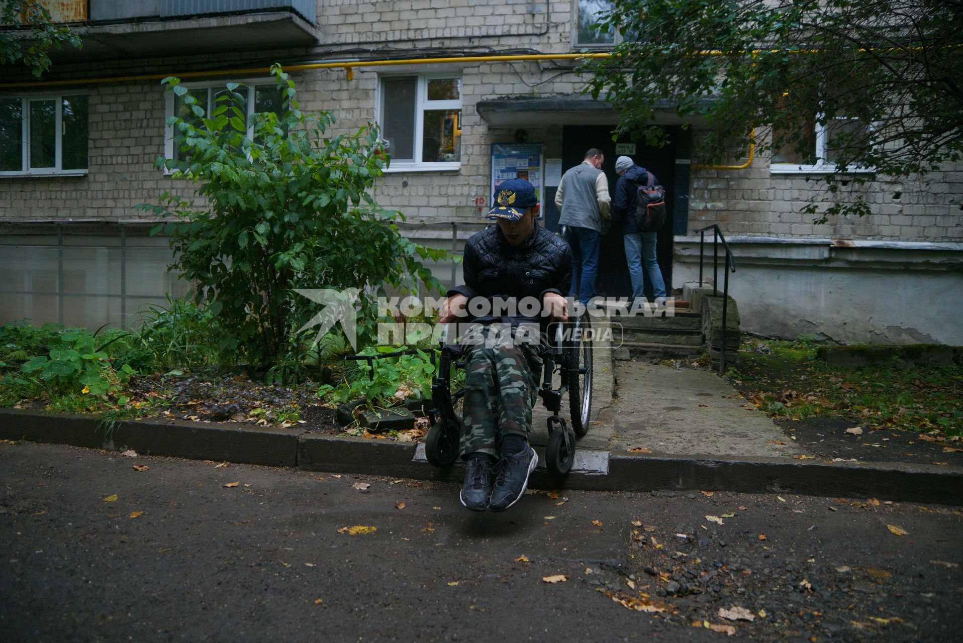 Екатеринбург. Инвалид-колясочник у жилого дома с пандусом, во время тестирования доступности городской среды для людей с ограниченными возможностями