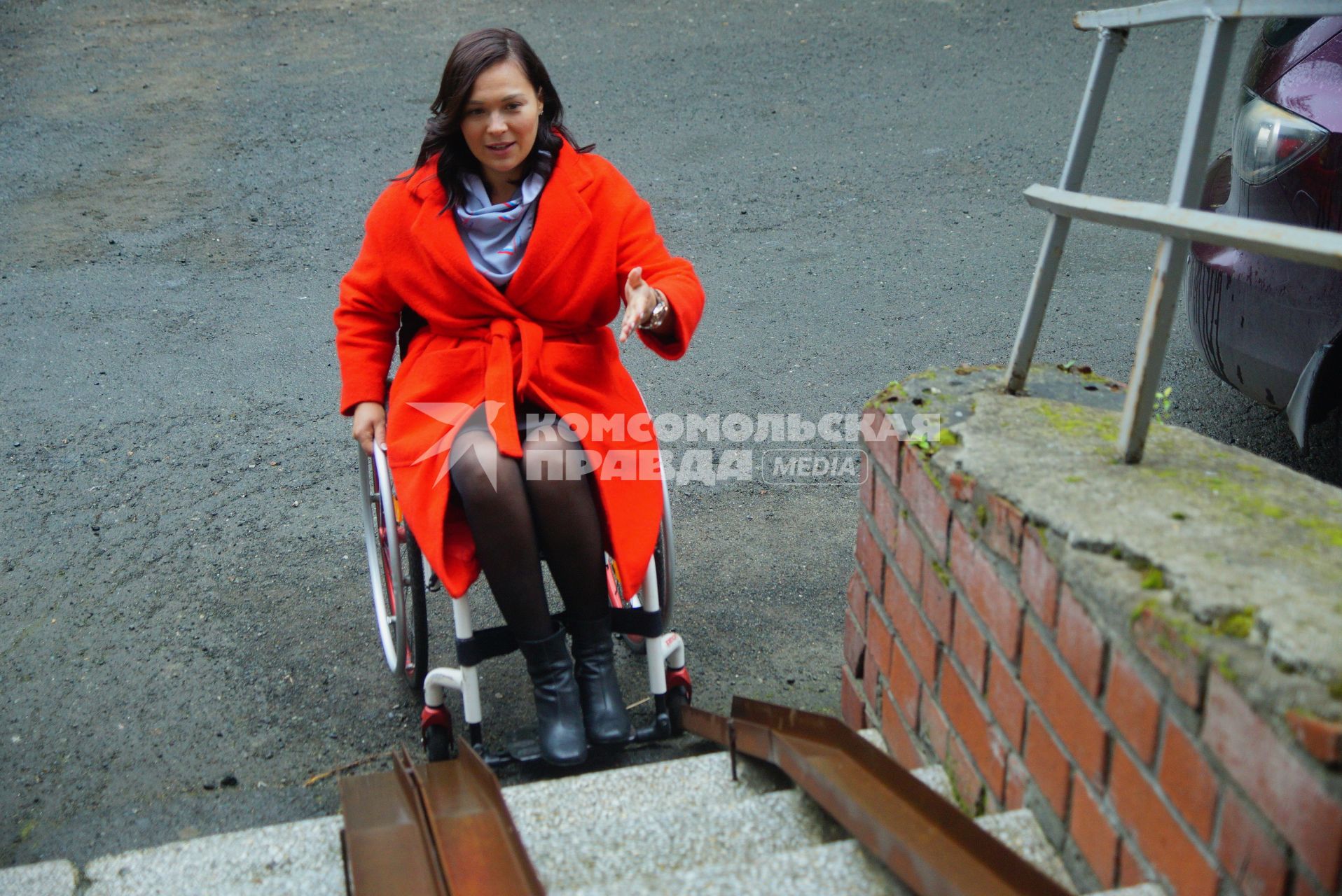 Екатеринбург. Женщина-инвалид-колясочник у жилого дома с пандусом, во время тестирования доступности городской среды для людей с ограниченными возможностями