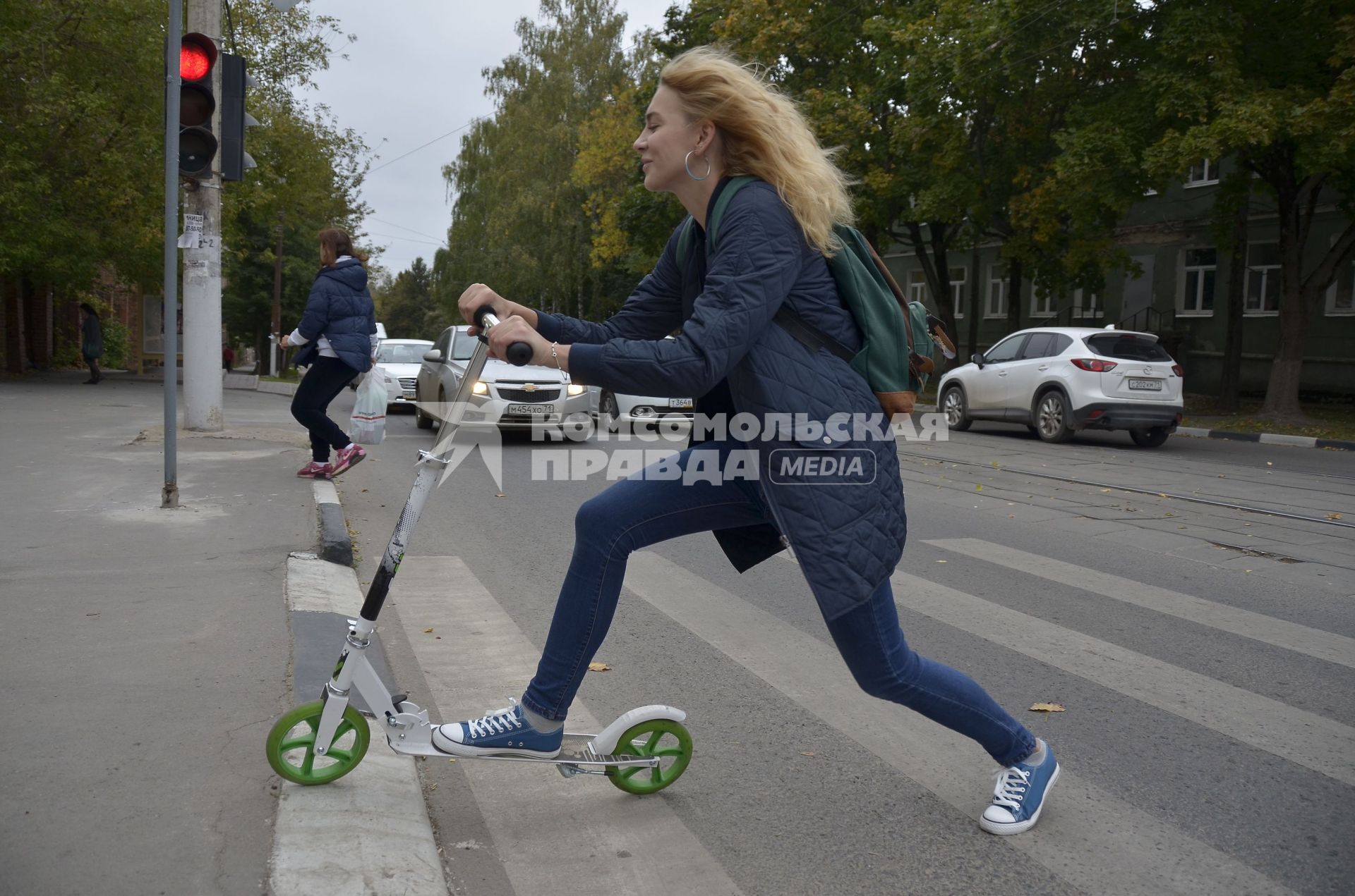 Тула. Девушка на самокате едет по городу.