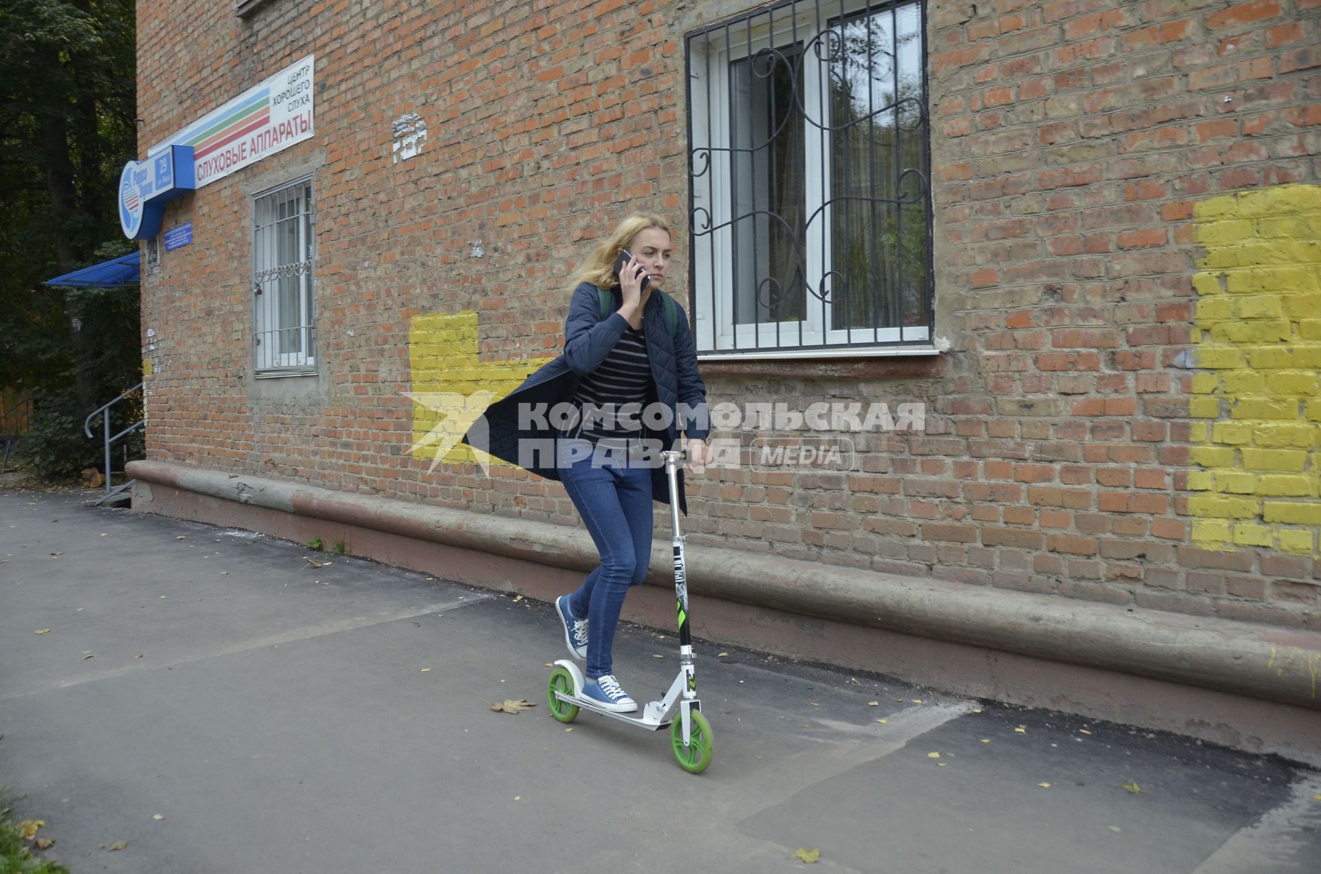 Тула. Девушка на самокате едет по городу.