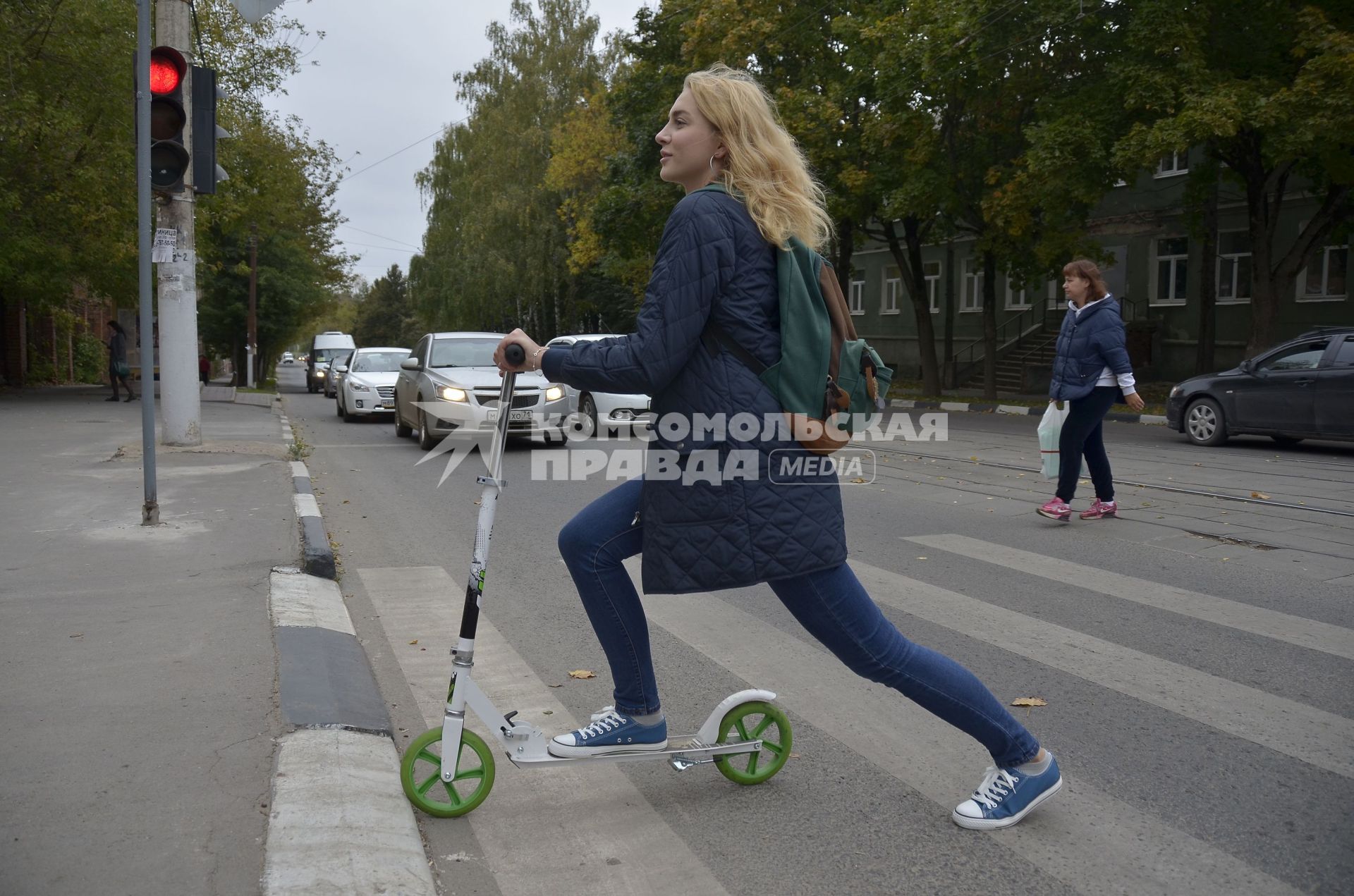 Тула. Девушка на самокате едет по городу.