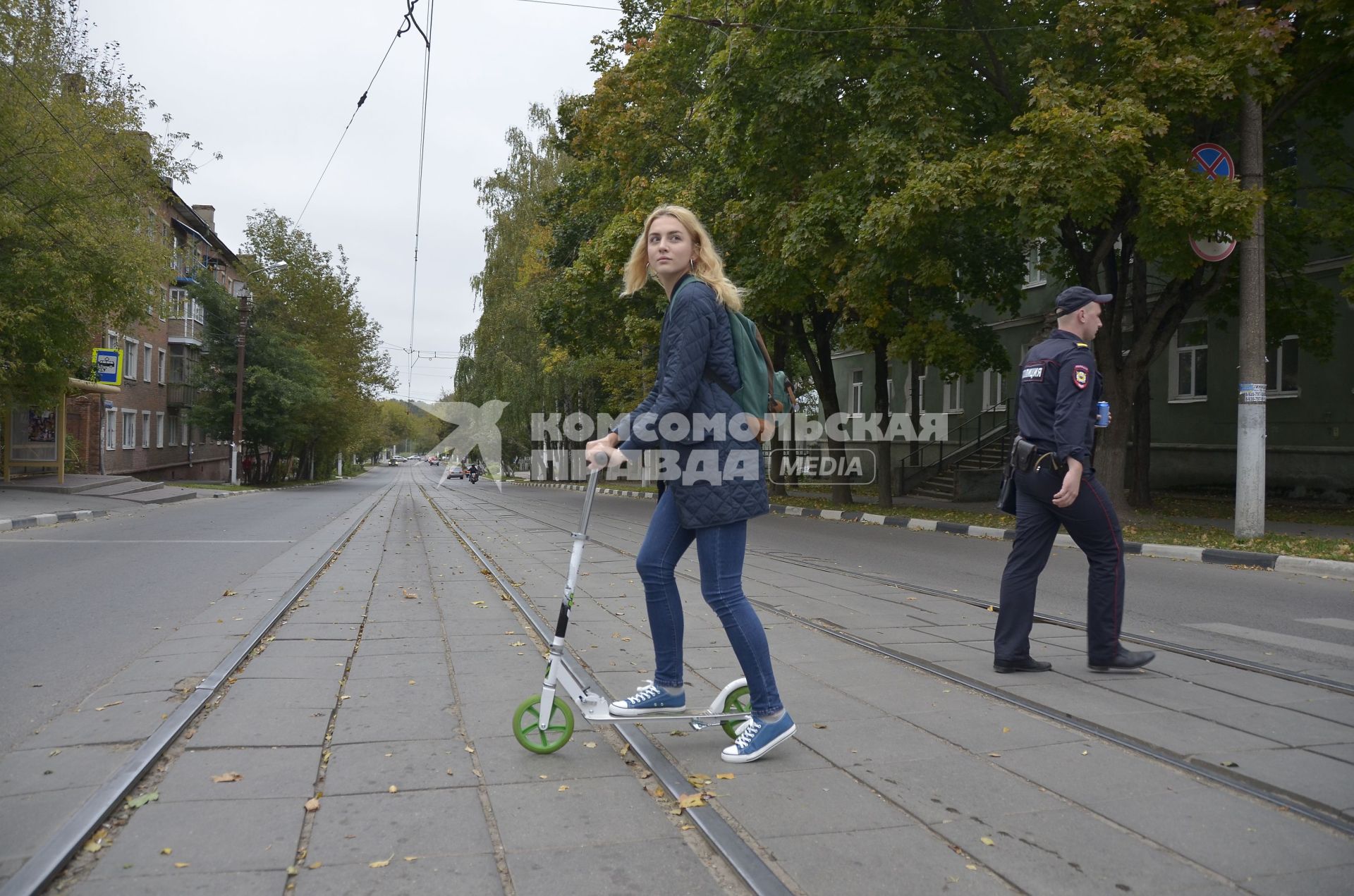 Тула. Девушка на самокате едет по городу.