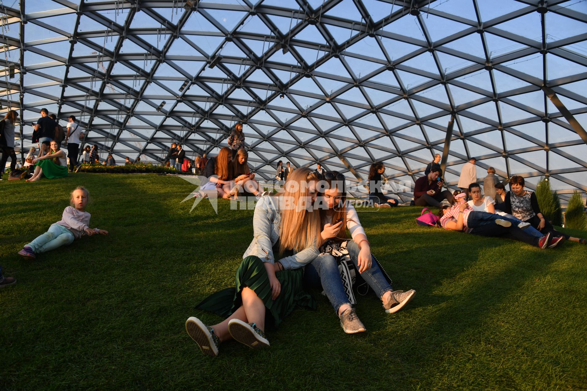 Москва. Посетители под стеклянным куполом на территории парка `Зарядье`.