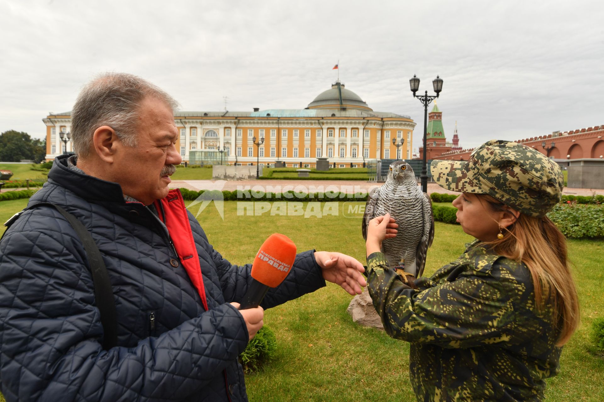 Москва. Корреспондент `Комсомольской правды` Александр Гамов и кремлевский сокольник Юлия Карасева с ястребом Альфой  на территории  Кремля.