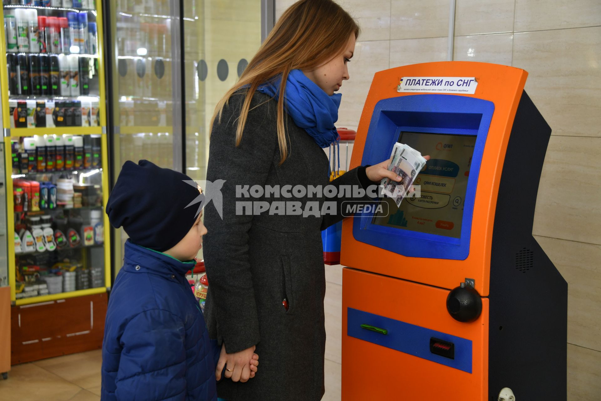 Москва.  Девушка с ребенком оплачивают мобильную связь.