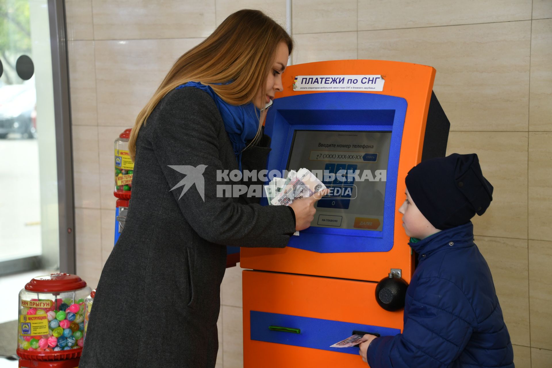 Москва.  Девушка с ребенком оплачивают мобильную связь.