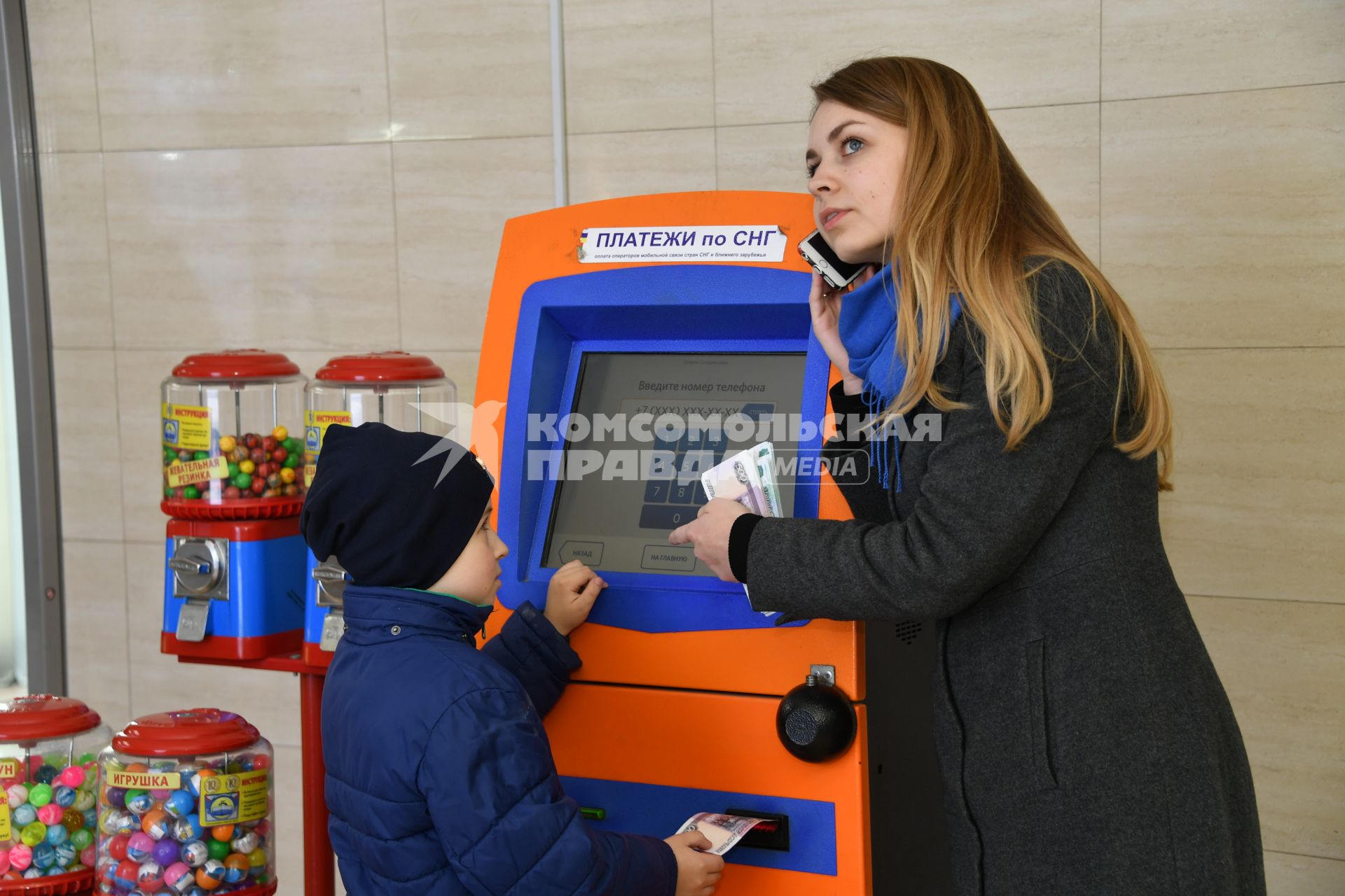 Москва.  Девушка с ребенком оплачивают мобильную связь.