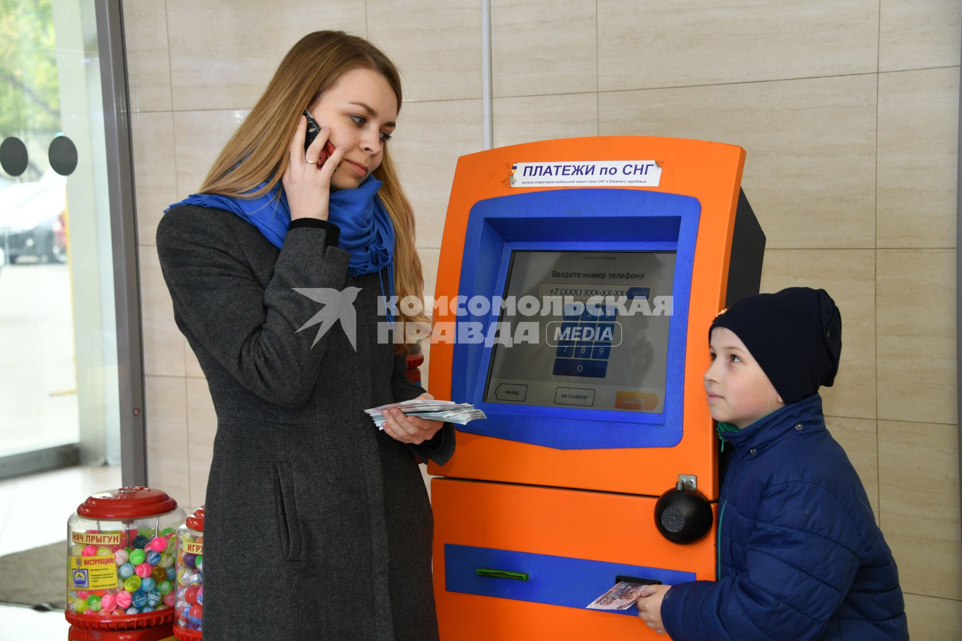 Москва.  Девушка с ребенком оплачивают мобильную связь.