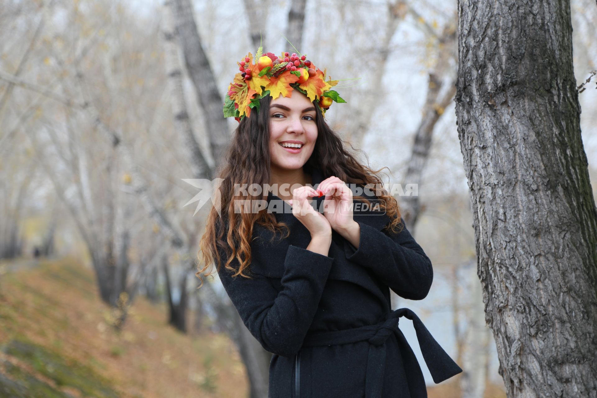 Красноярск.  Девушка в венке из осенних листьев  гуляет в парке.