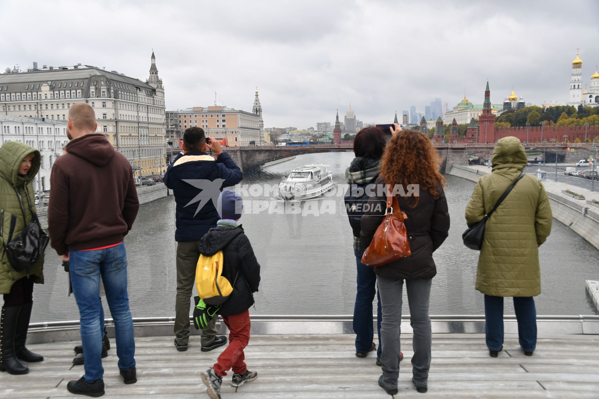 Москва.   Посетители  фотографируют на Парящем мосту ландшафтного парка `Зарядье`.