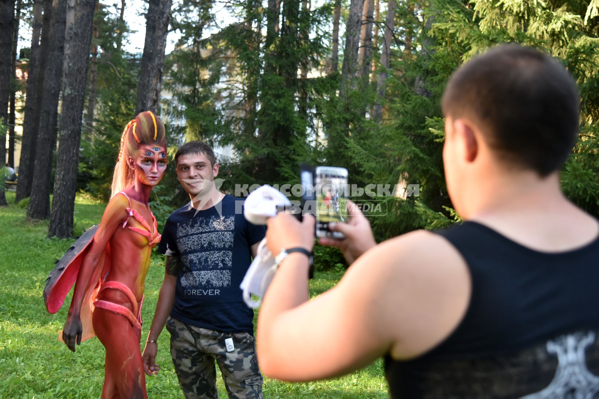 Новосибирск.  Молодой человек фотографируется с участницей конкурса боди-арт.