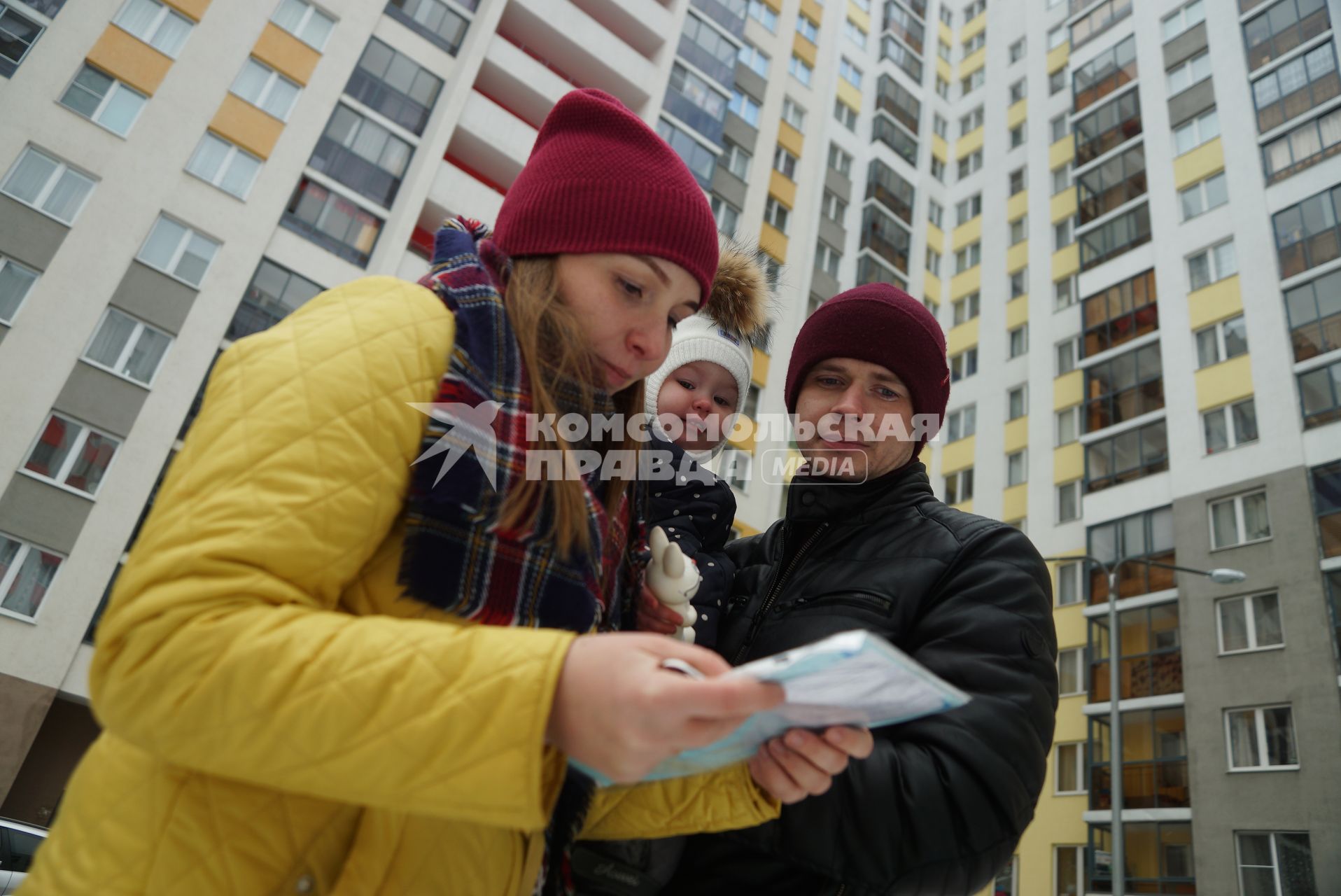 Екатеринбург.  Мужчина и женщина с ребенком   у новостройки.