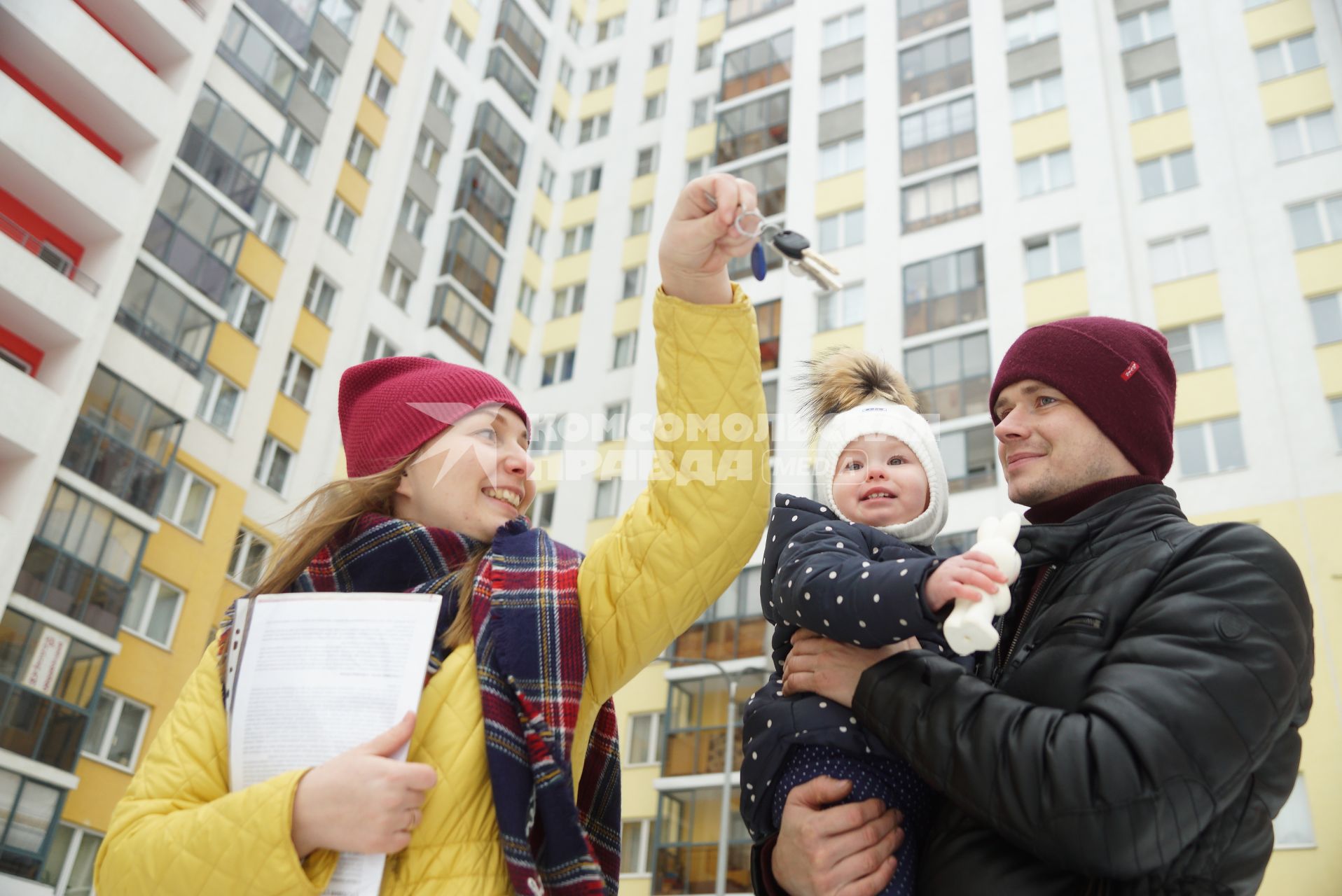 Екатеринбург.  Женщина показывает ключи от квартиры мужчине с ребенком.