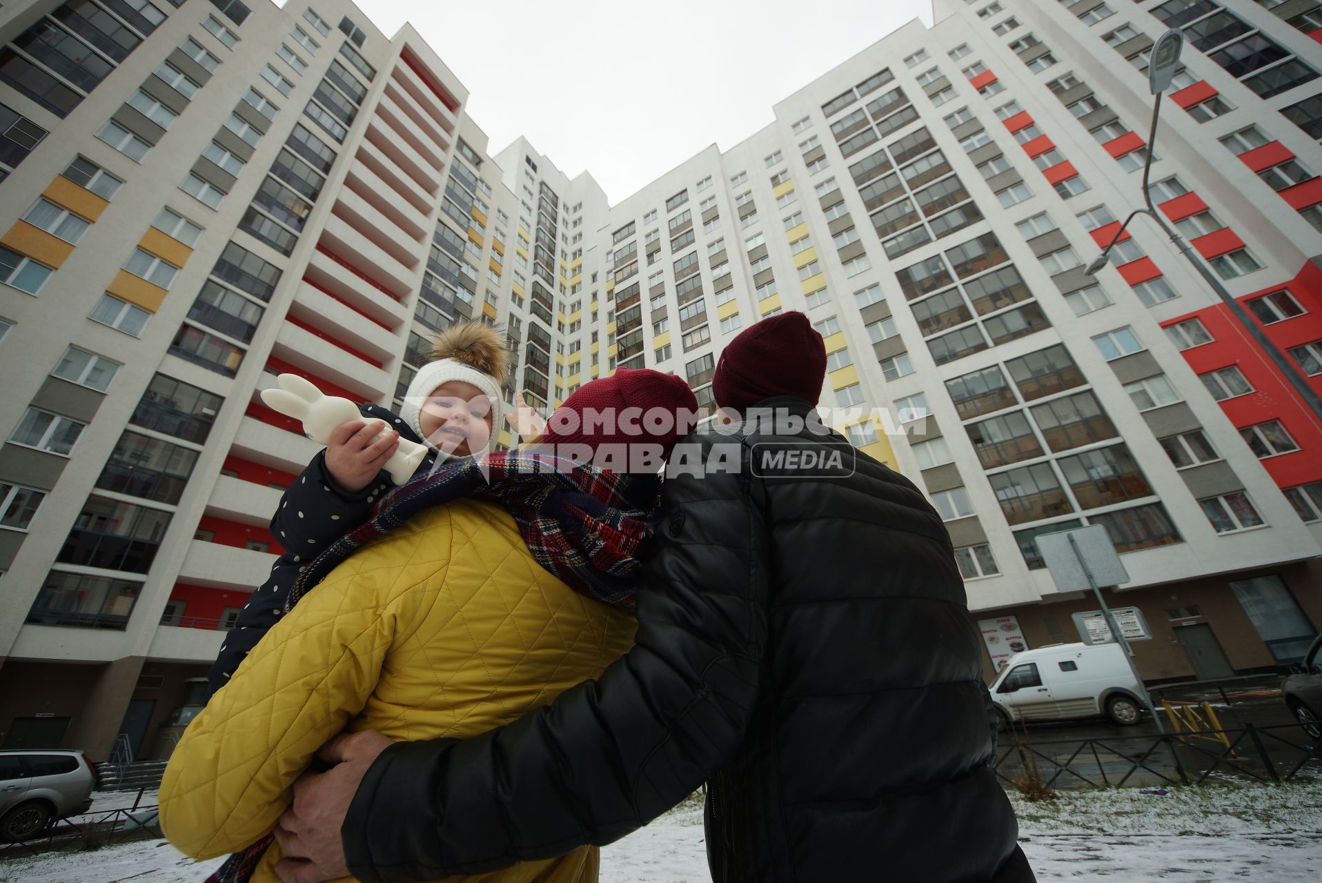 Екатеринбург.  Мужчина и женщина с ребенком смотрят на новостройку.