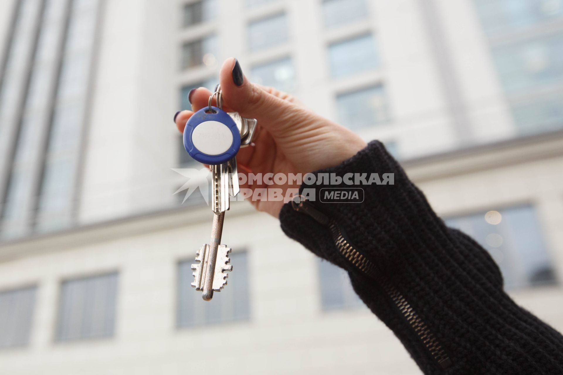 Санкт-Петербург.  Ключи от квартиры на фоне многоэтажного жилого дома.