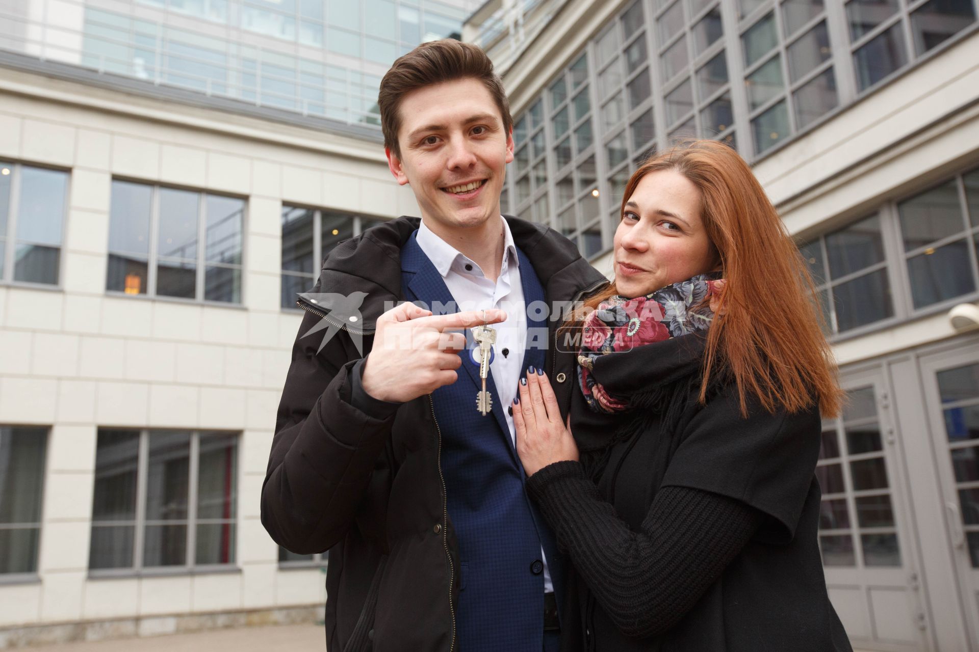 Санкт-Петербург. Молодые люди показывают ключи от квартиры в новостройке.