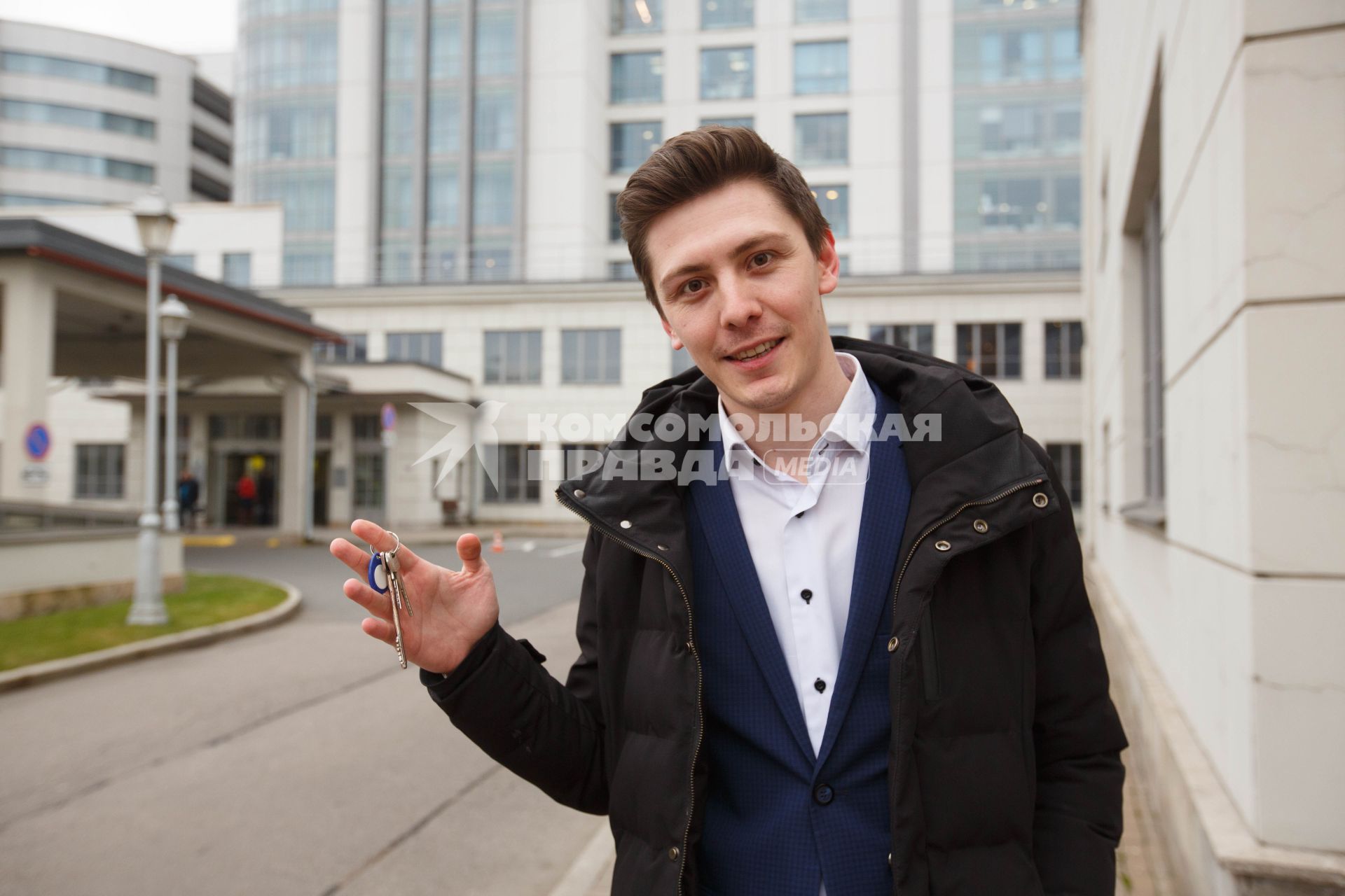 Санкт-Петербург.  Молодой человек держит в руке ключи от квартиры.