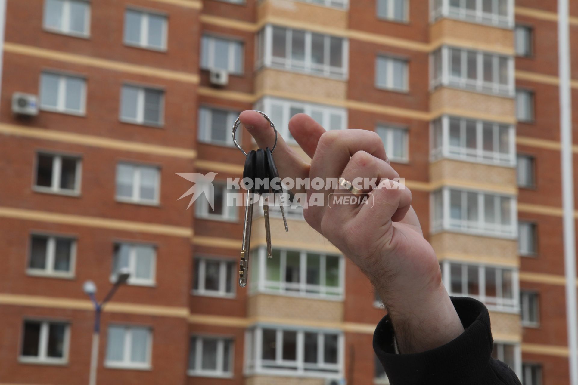 Иркутск.  Ключи от квартиры на фоне многоэтажного жилого дома.