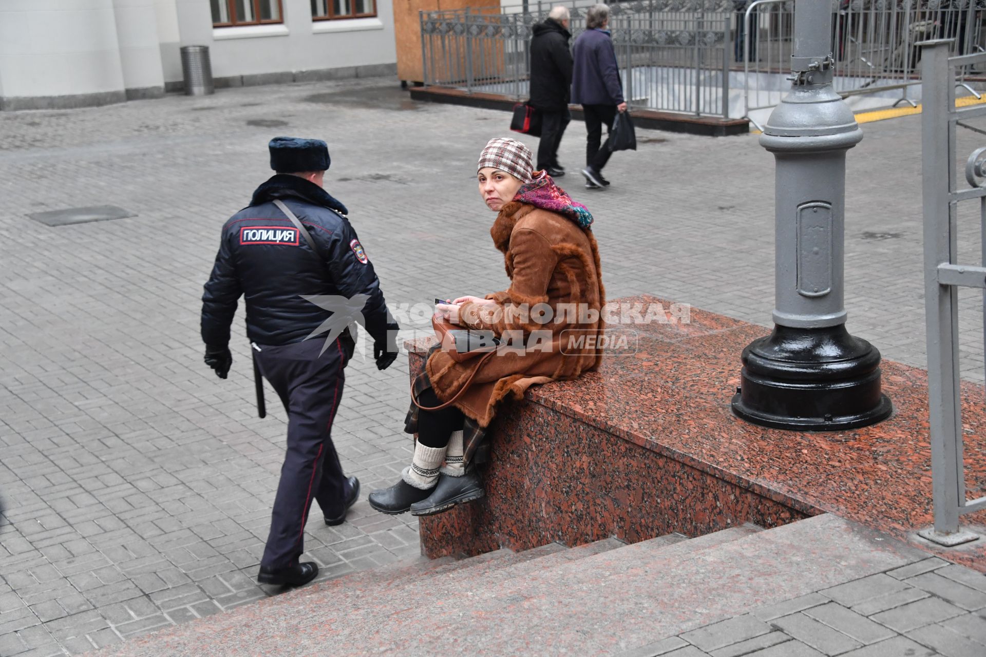 Москва.  Женщина  сидит у вокзала.