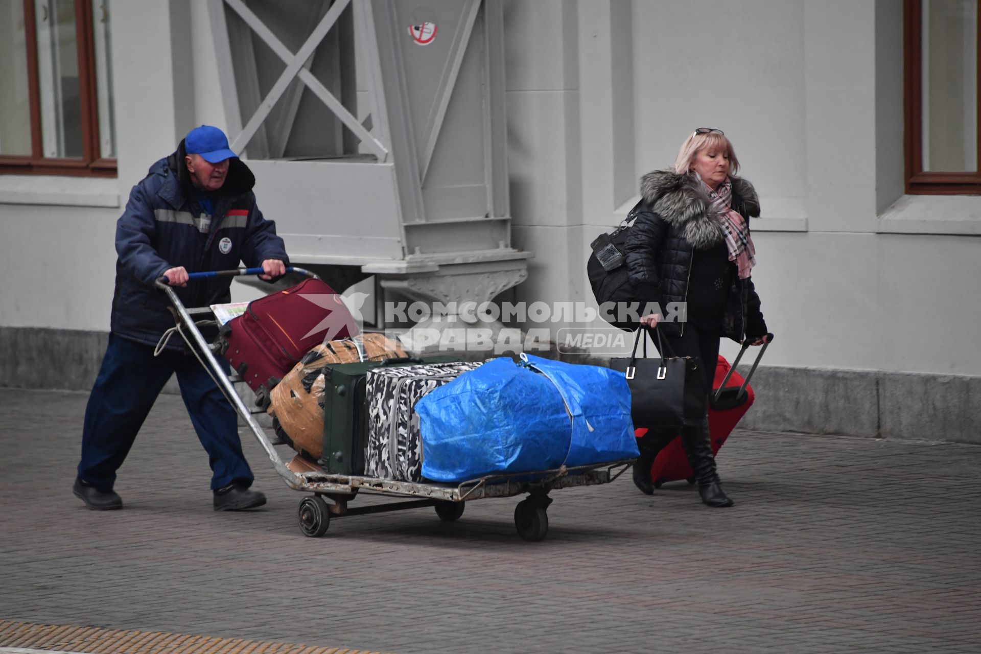 Москва.  Носильщик перевозит багаж.