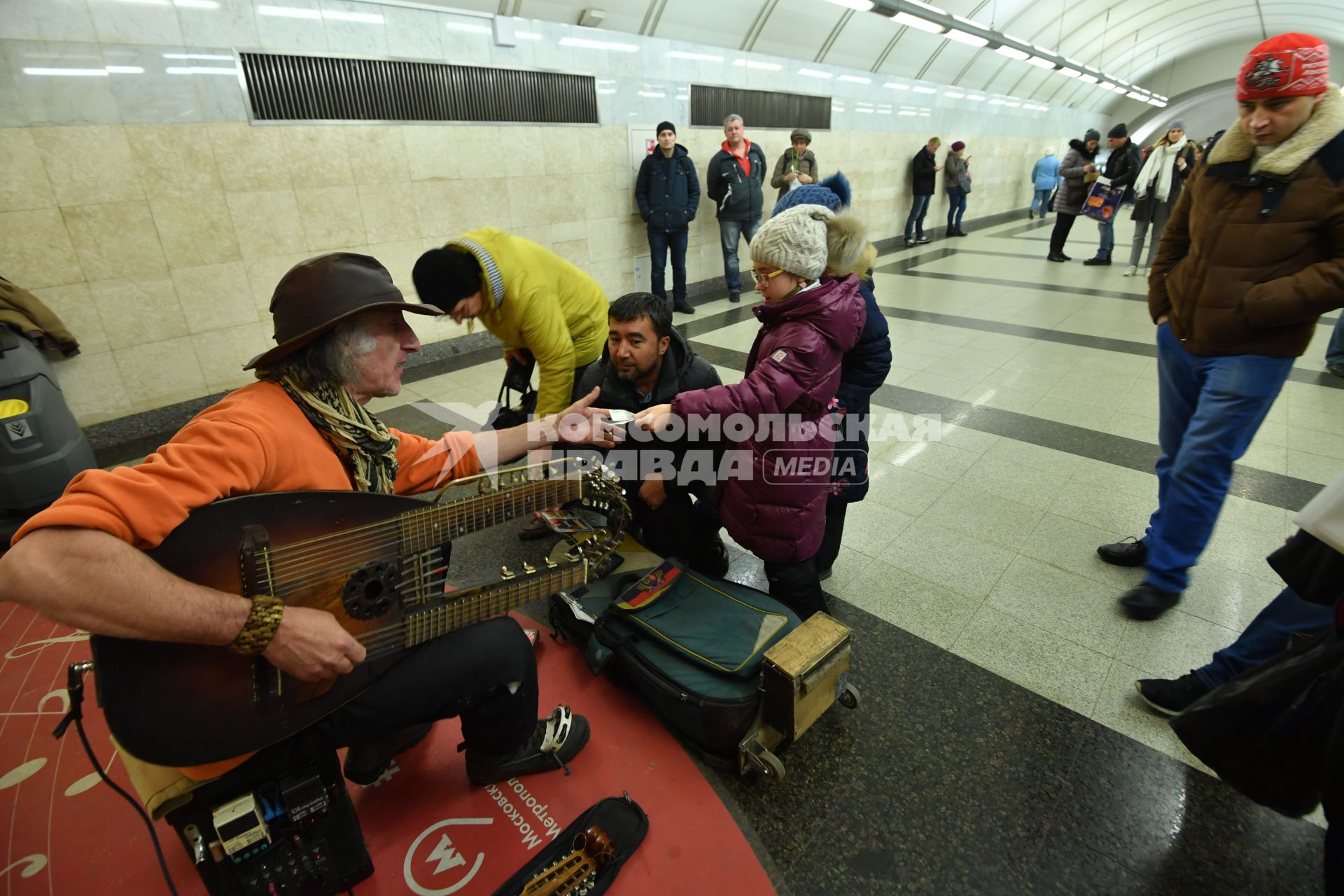 Москва. Девочка дает деньги музыканту в метро.