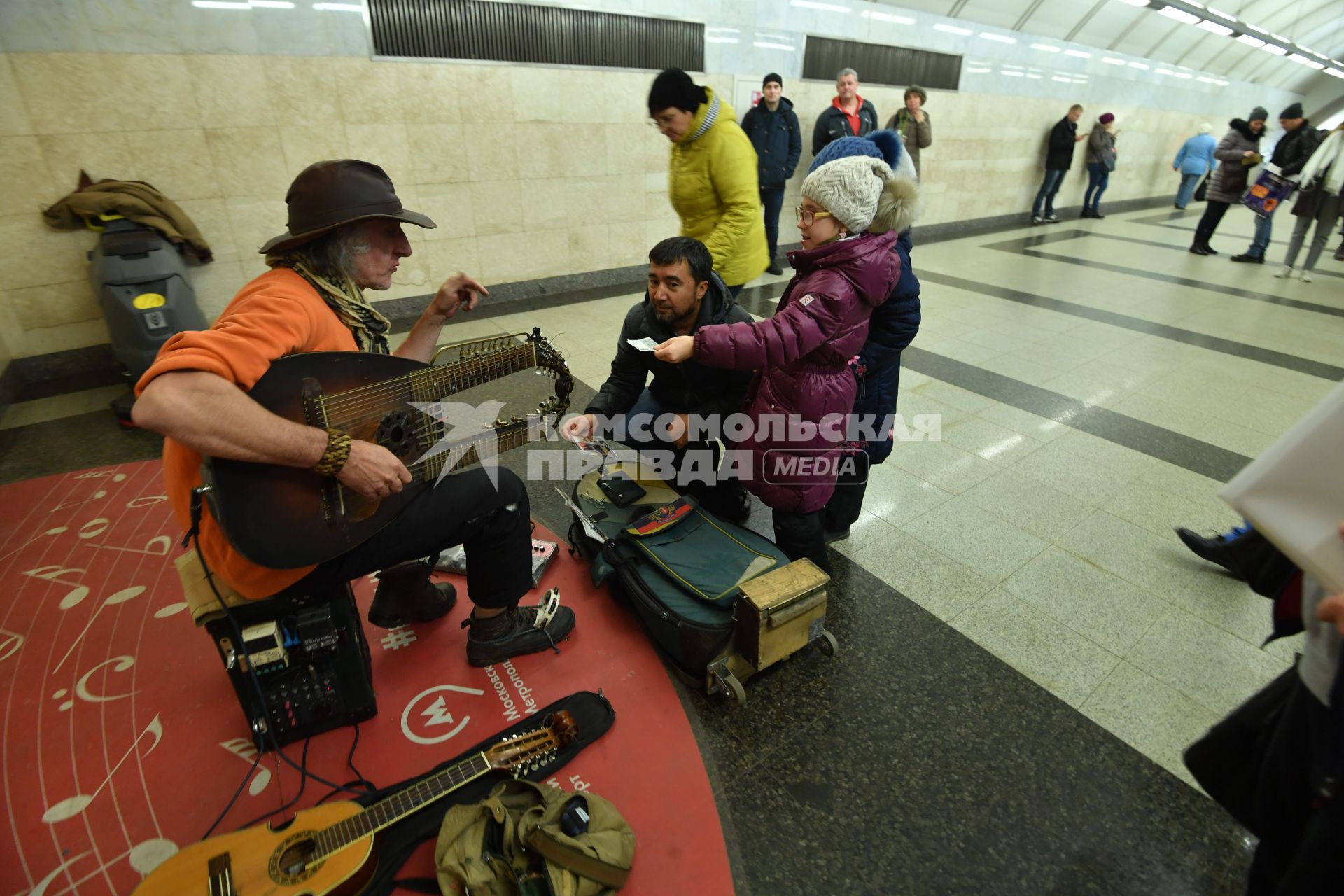 Москва. Девочка дает деньги музыканту в метро.