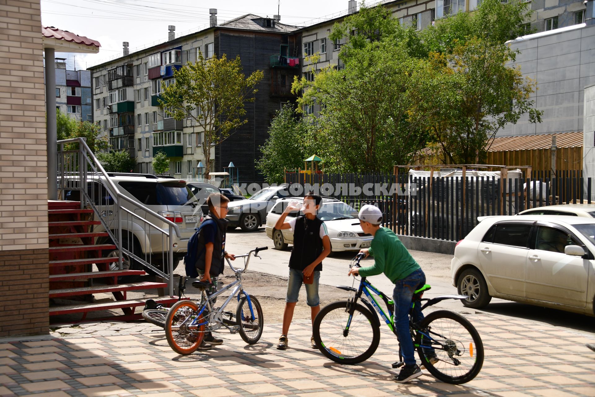 Сахалин, Южно-Сахалинск.  Мальчики  с велосипедами на улице города.