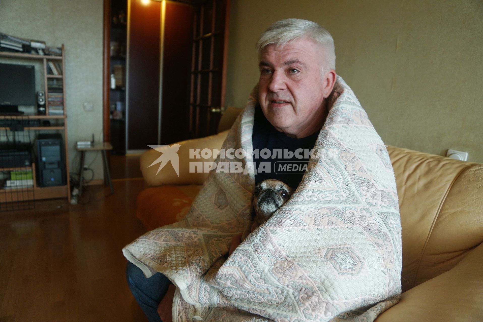 Екатеринбург. Мужчина с собачкой греются под пледом в квартире, где еще не включили отопление