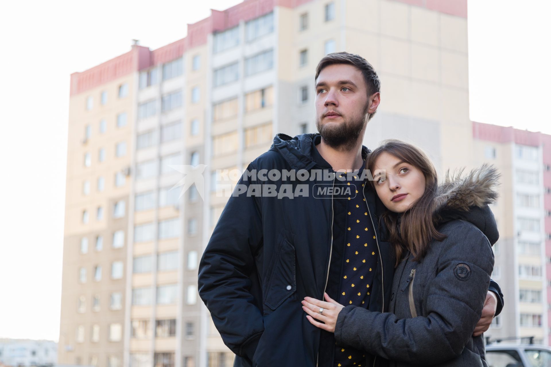 Челябинск.   Молодой человек и девушка у жилого многоэтажного дома.