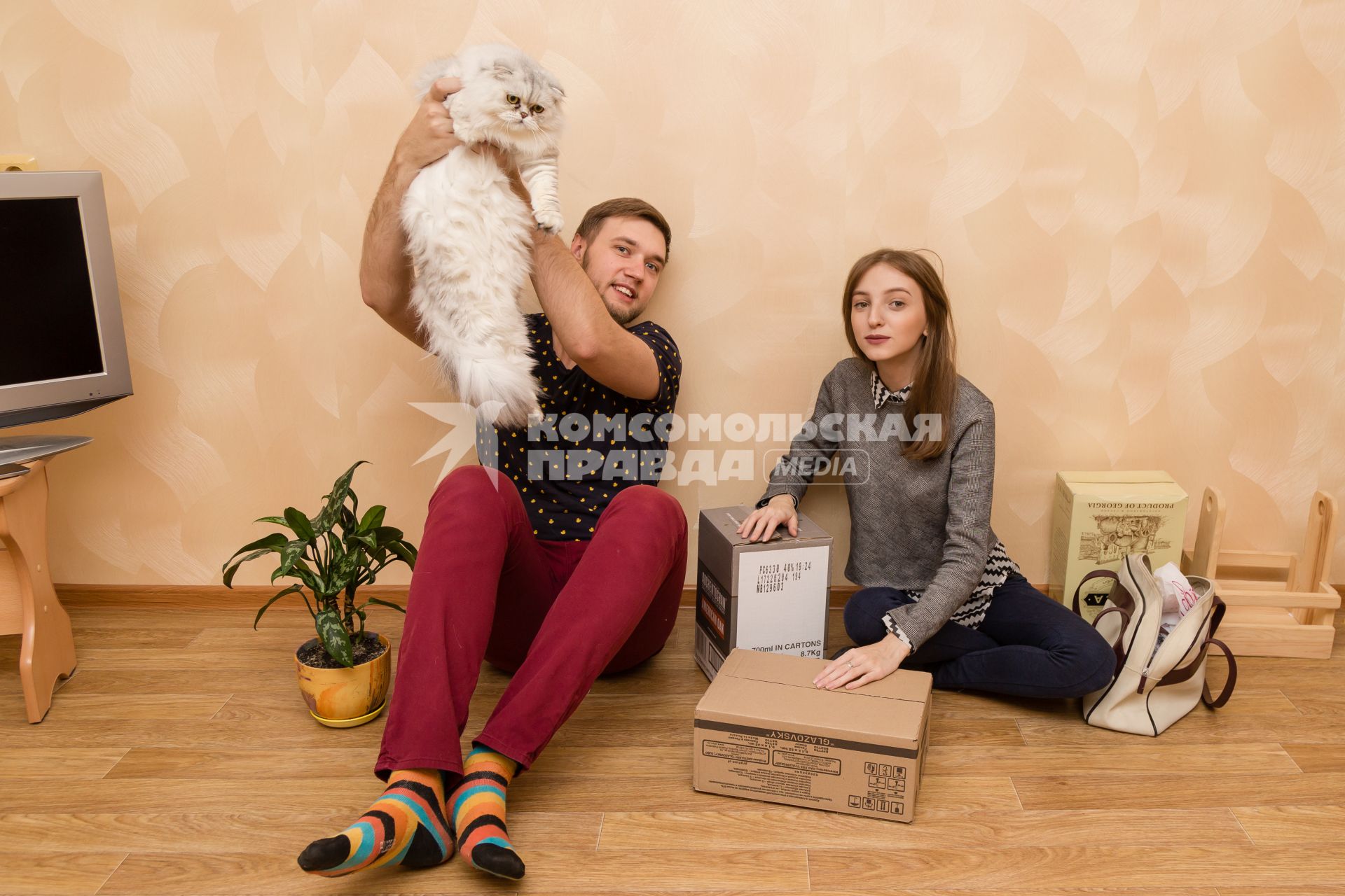 Челябинск. Девушка и молодой человек  с котом в новой квартире.
