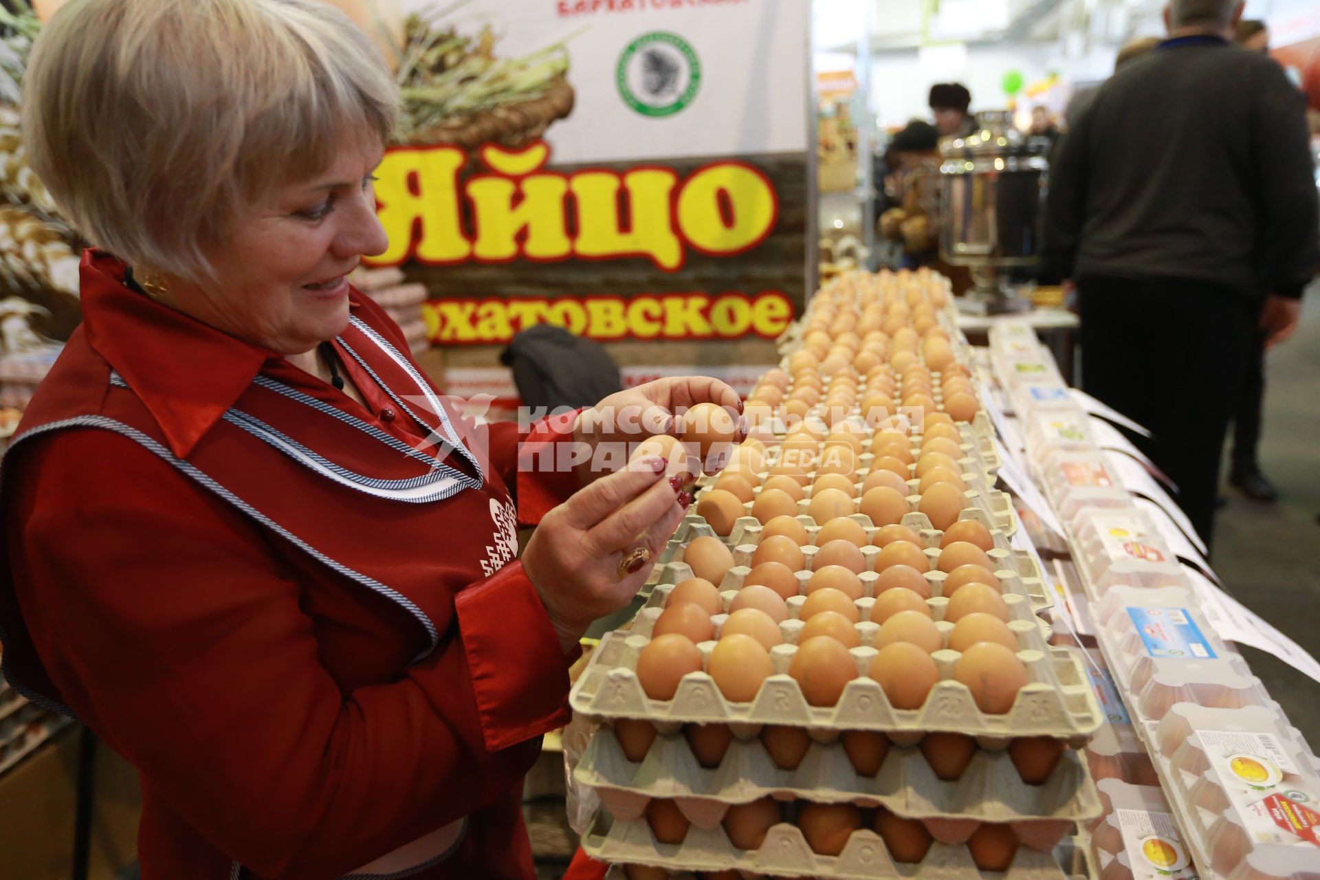 Красноярск.  Продавщица торгует куриными яйцами на ярмарке.