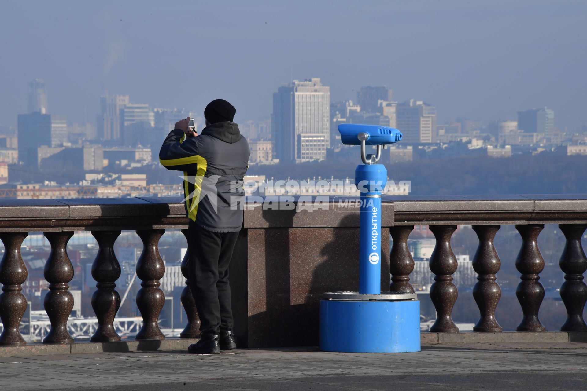 Москва.  Мужчина фотографирует  на смотровой площадке Воробьевых гор.