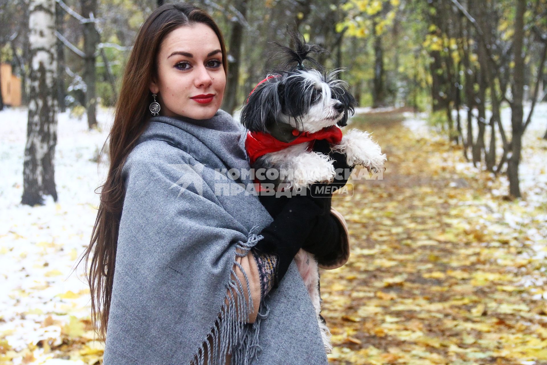 Нижний Новгород. Женщина держит на руках собаку одетую в комбинезон.