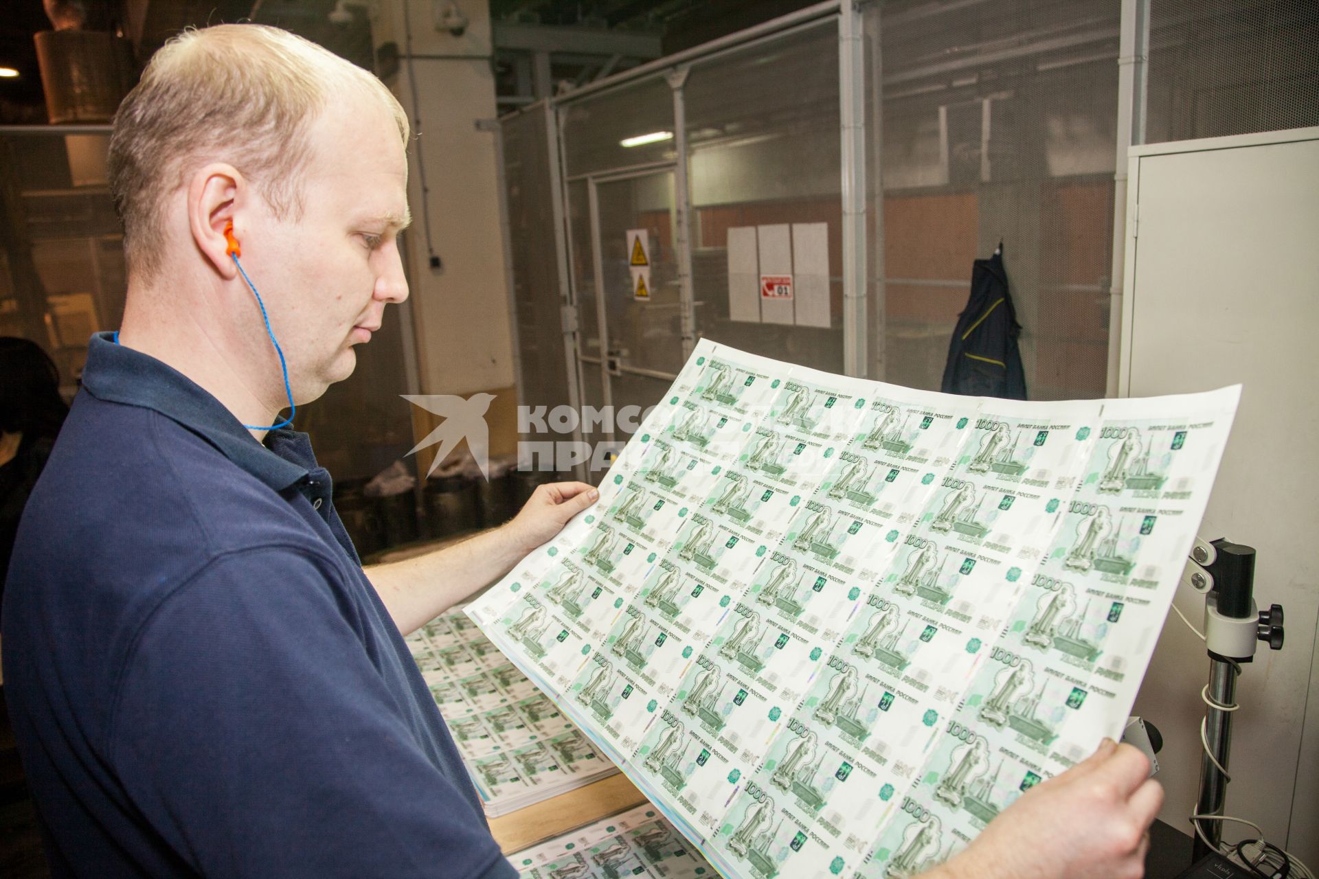 Пермь. Сотрудник фабрики Гознак просматривает листы с денежными купюрами  номиналом 1000 рублей.