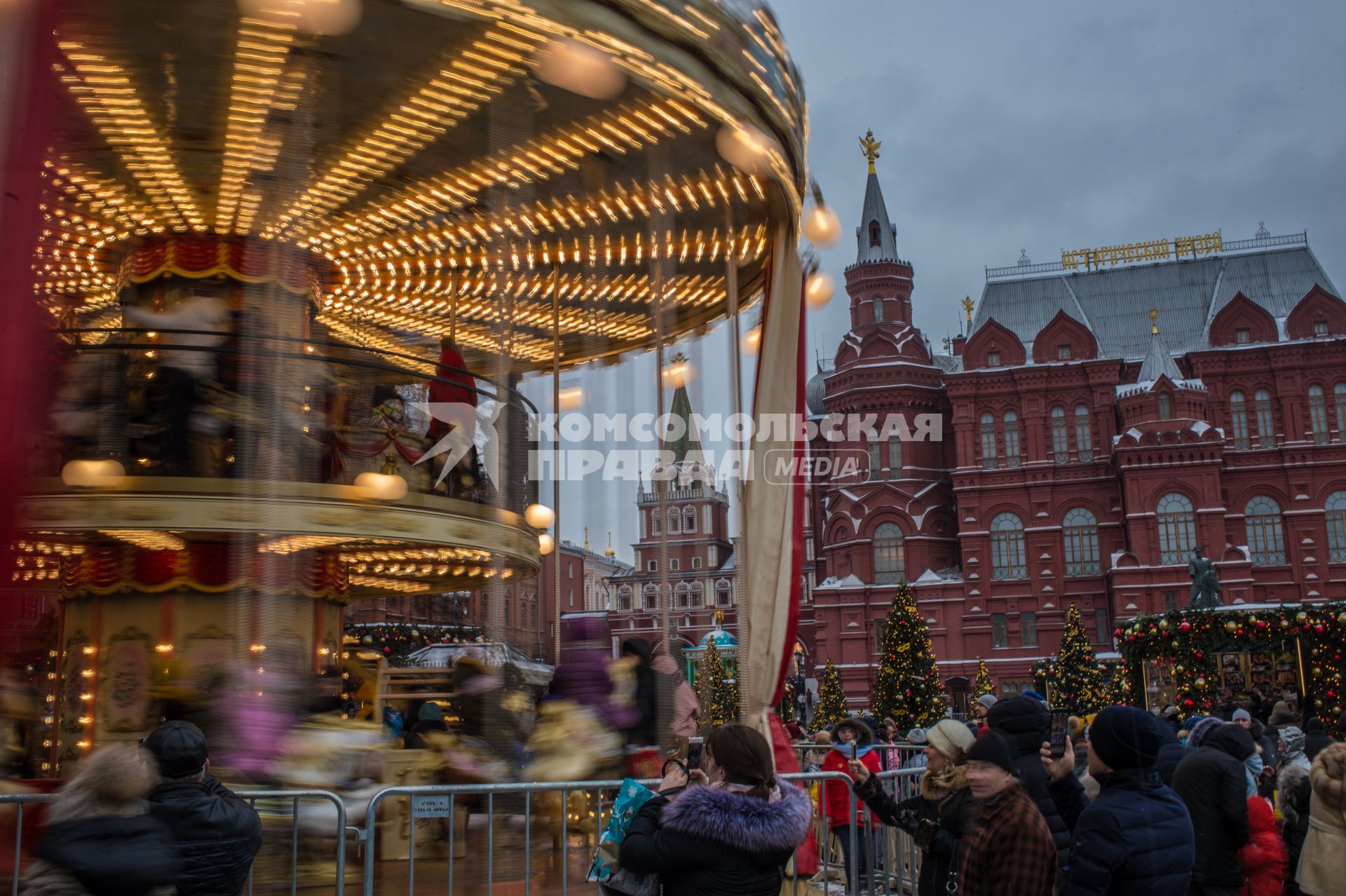 Москва.  Дети катаются на карусели на  Манежной Площади.