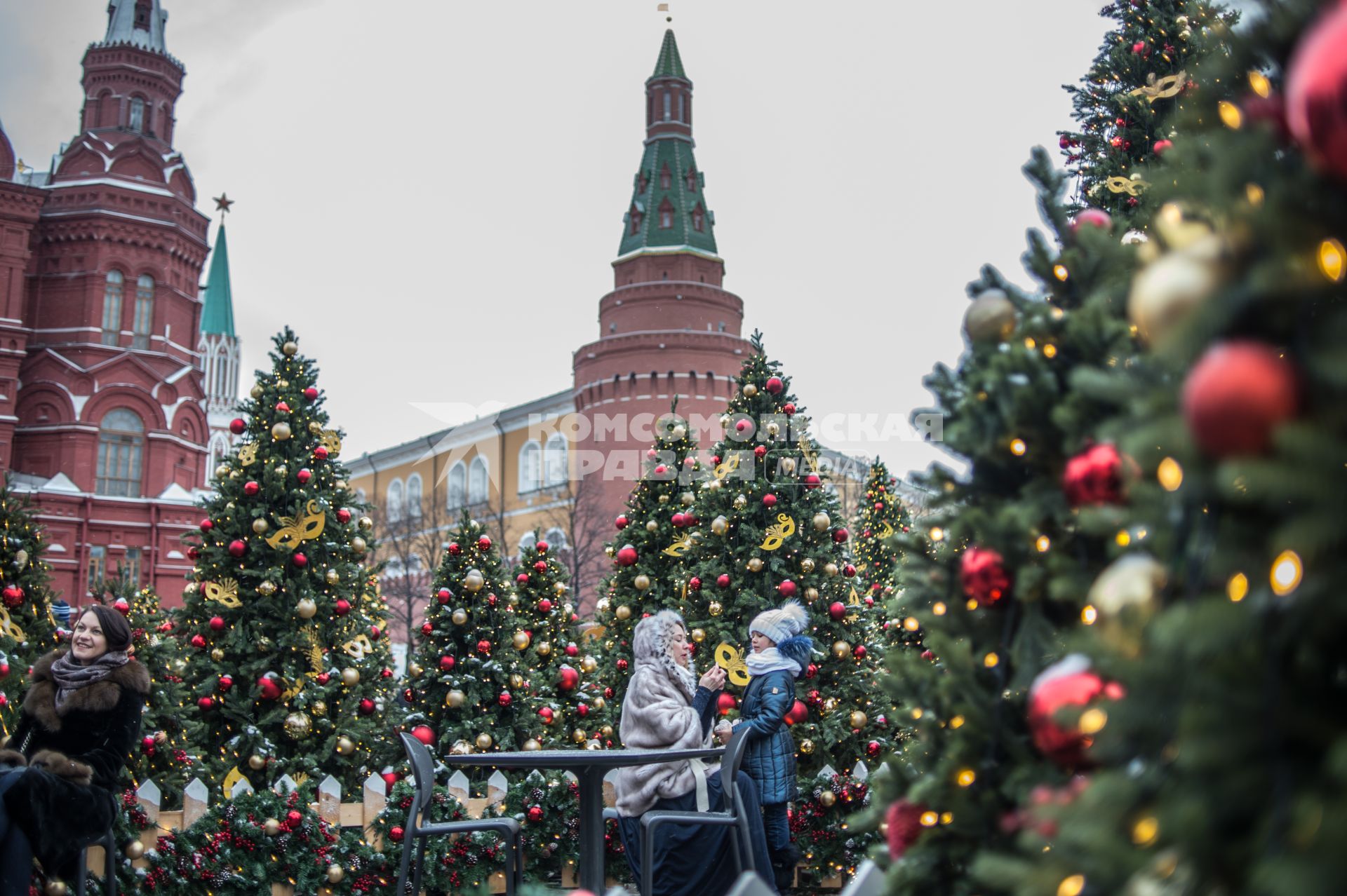 Москва. Женщина с девочкой  у новогодних  елок на  Манежной Площади.