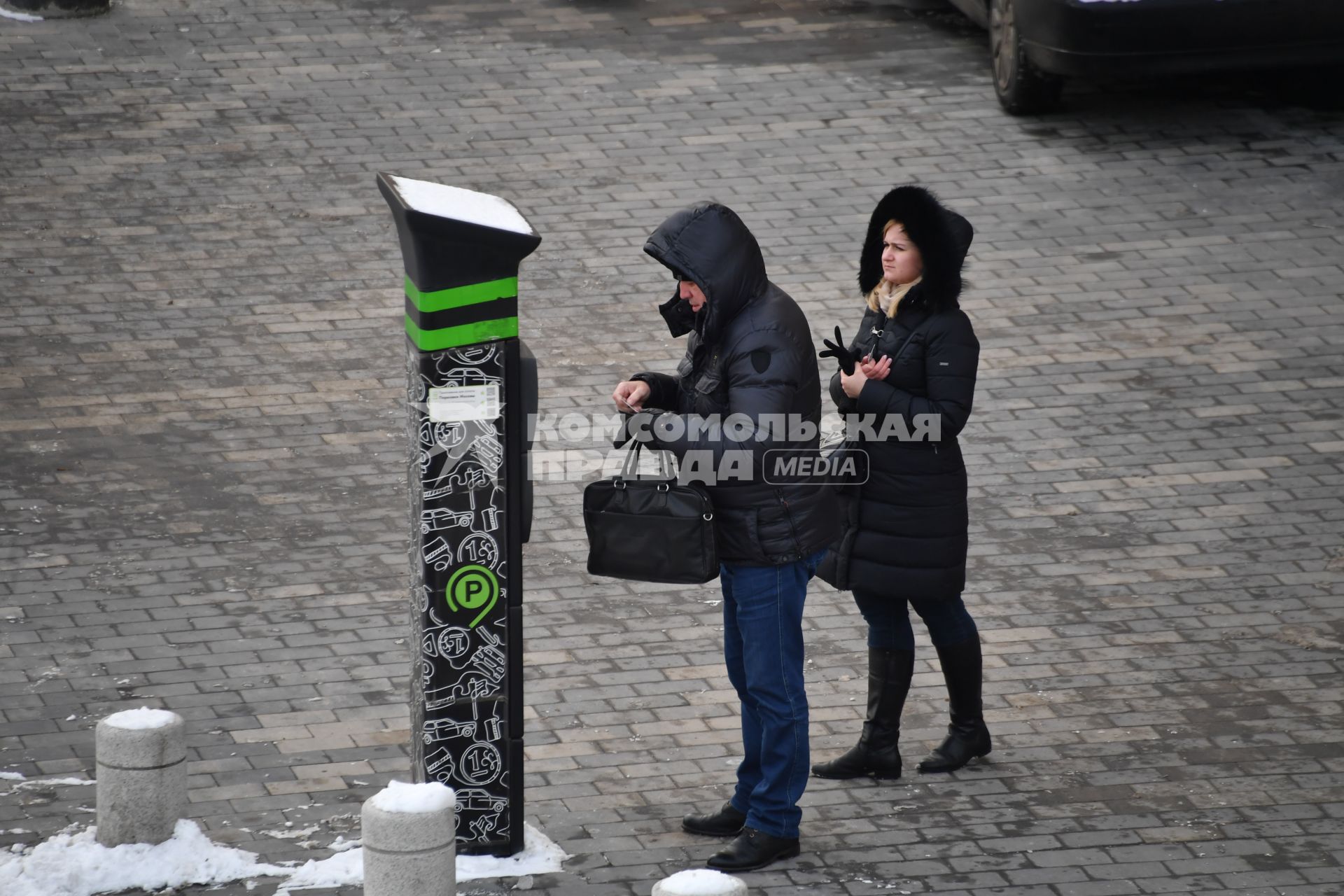 Москва. Мужчина оплачивает парковку автомобиля через паркомат.