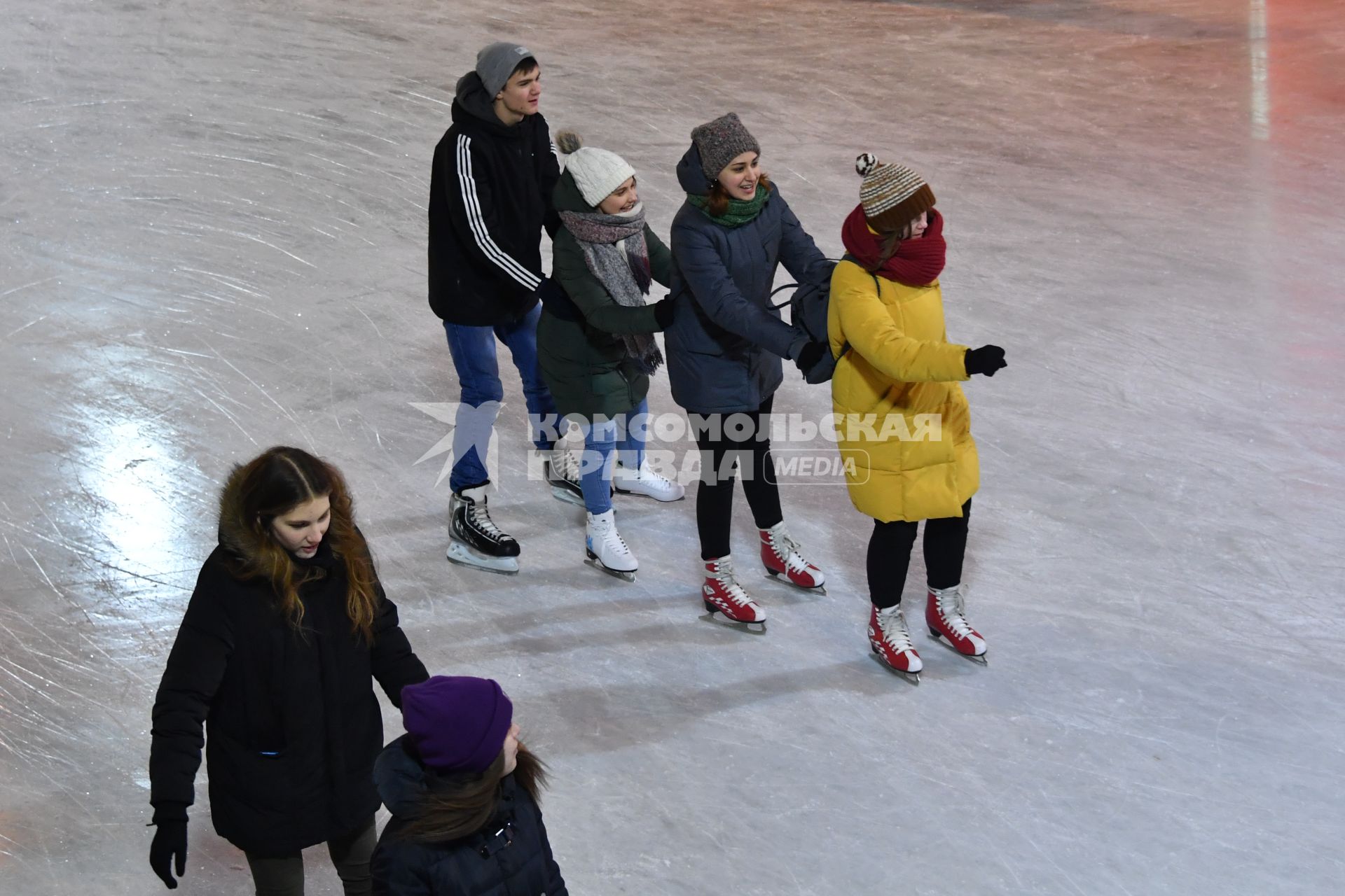 Москва.  Молодые люди катаются на катке в Парке Горького.