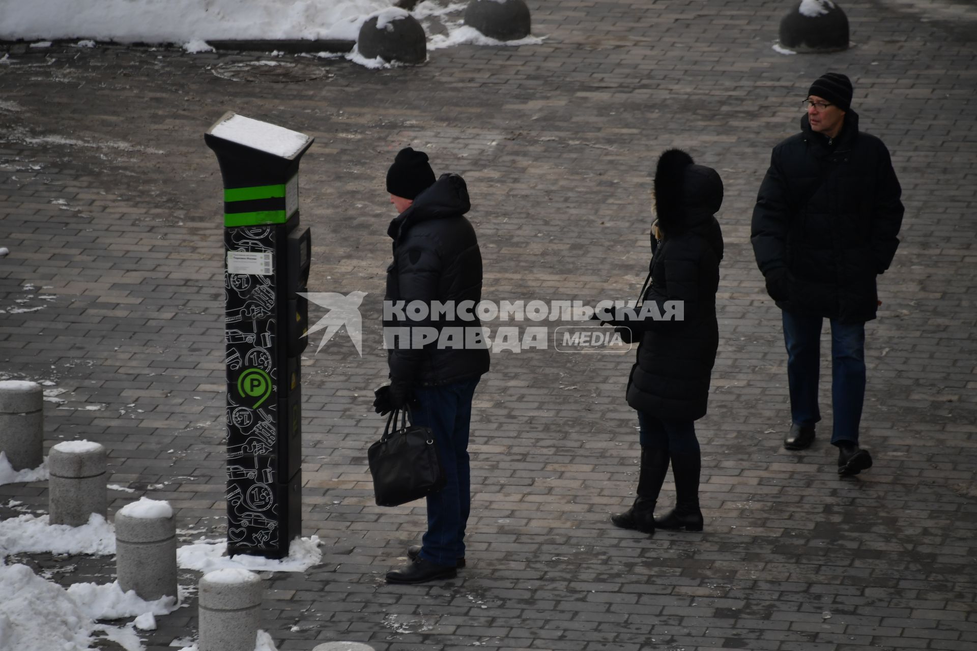 Москва. Мужчина оплачивает парковку автомобиля через паркомат.