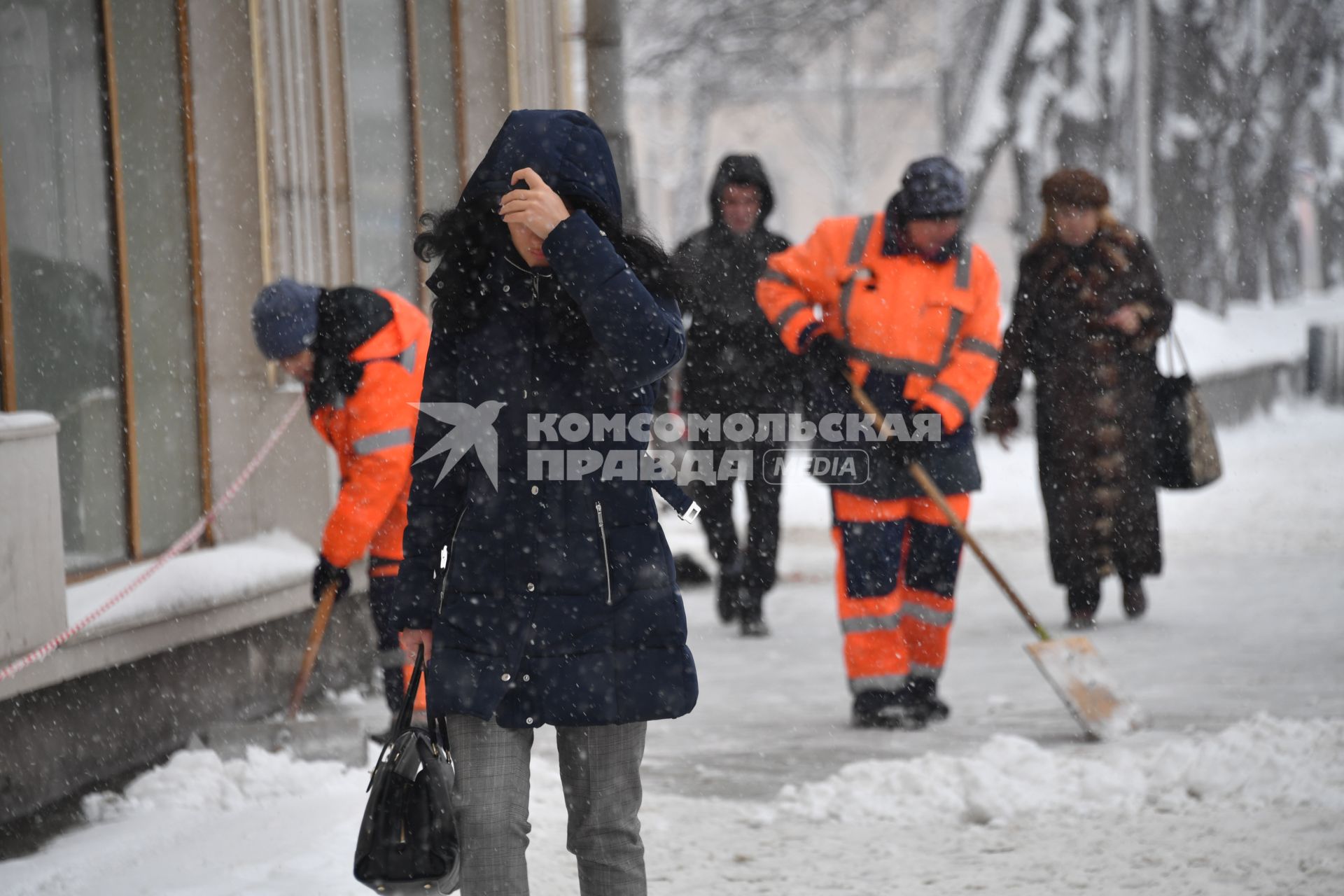 Москва.  Девушка во время снегопада на одной из улиц города.